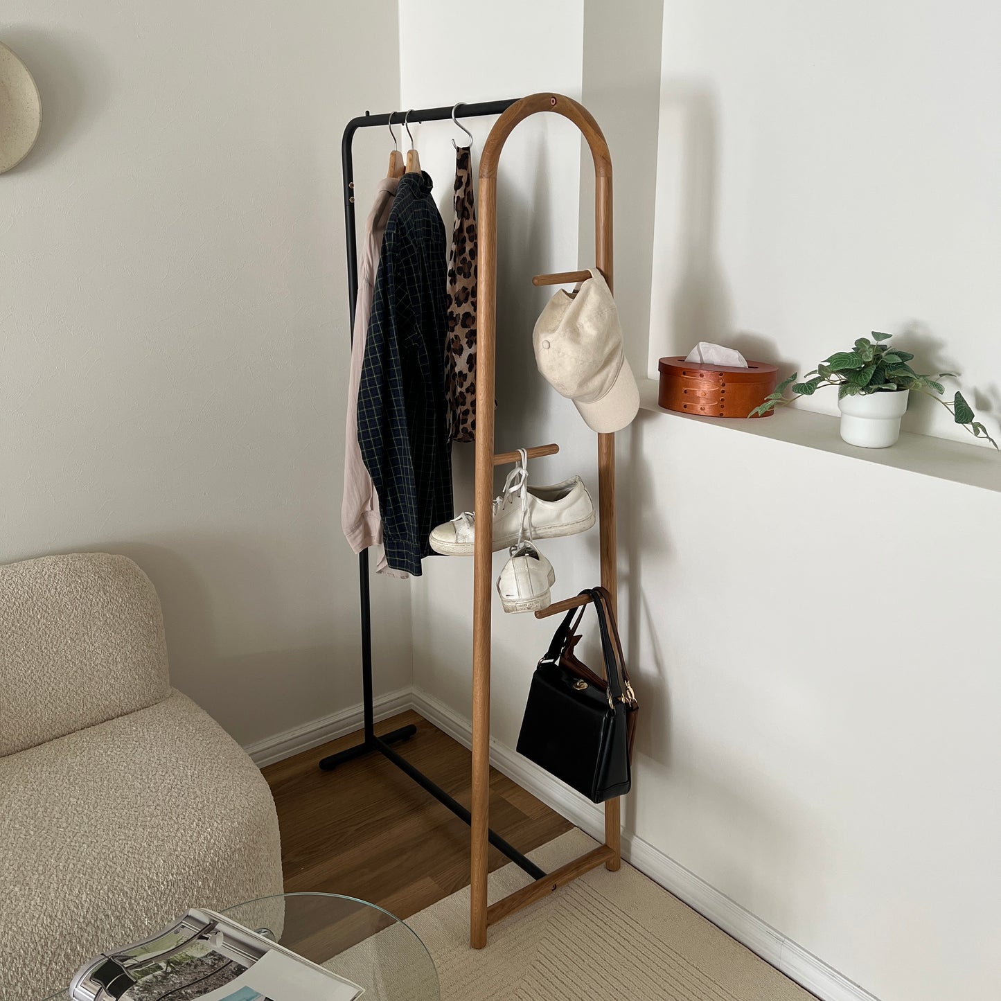 オーク材とブラックスチールのハンガーラックを部屋の角に置いている様子