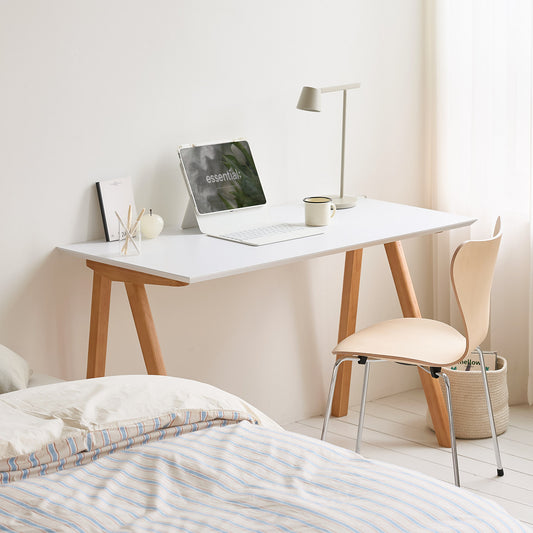 ホワイト天板のバルト無垢材デスクをベッド横に置いている様子