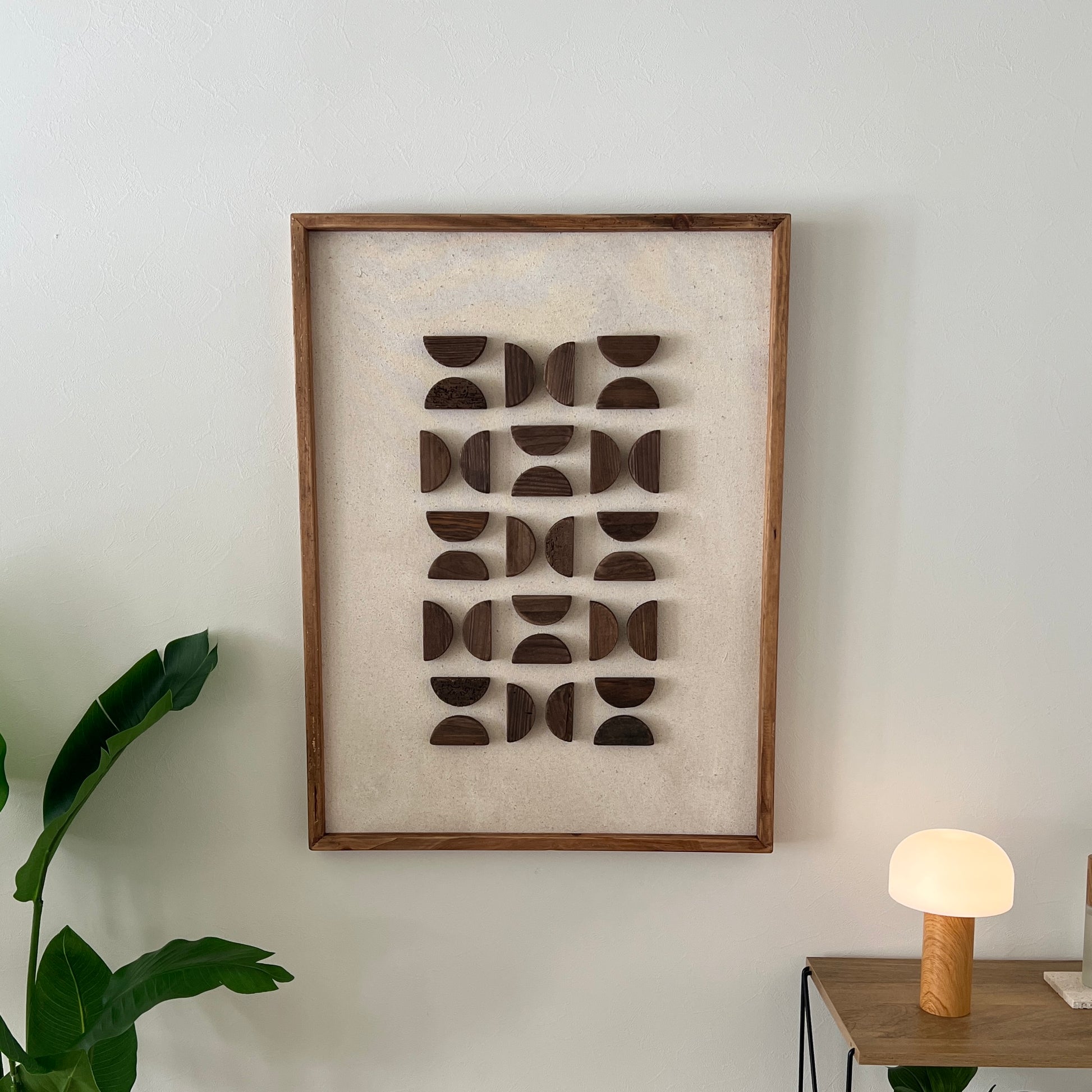 半円型の立体的なウッドパーツが幾何学的に貼り付けられたアート