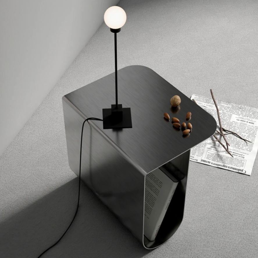 特徴的なデザインのシルバーのサイドテーブルにライトが置かれてある