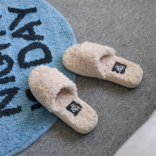 モコモコしたブークレ素材のスリッパが床に置かれている