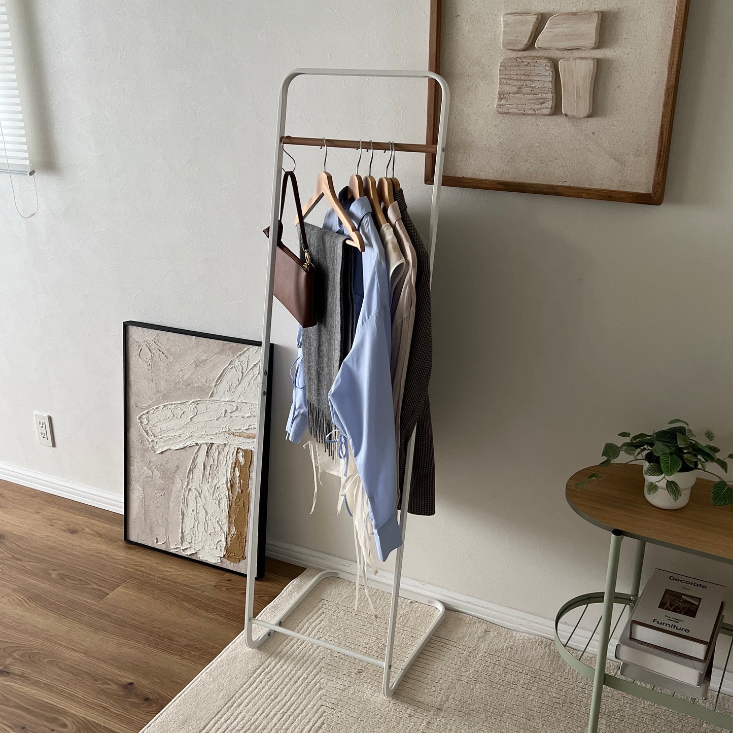 スチールと木製バーのハンガーラックを部屋に置いている様子