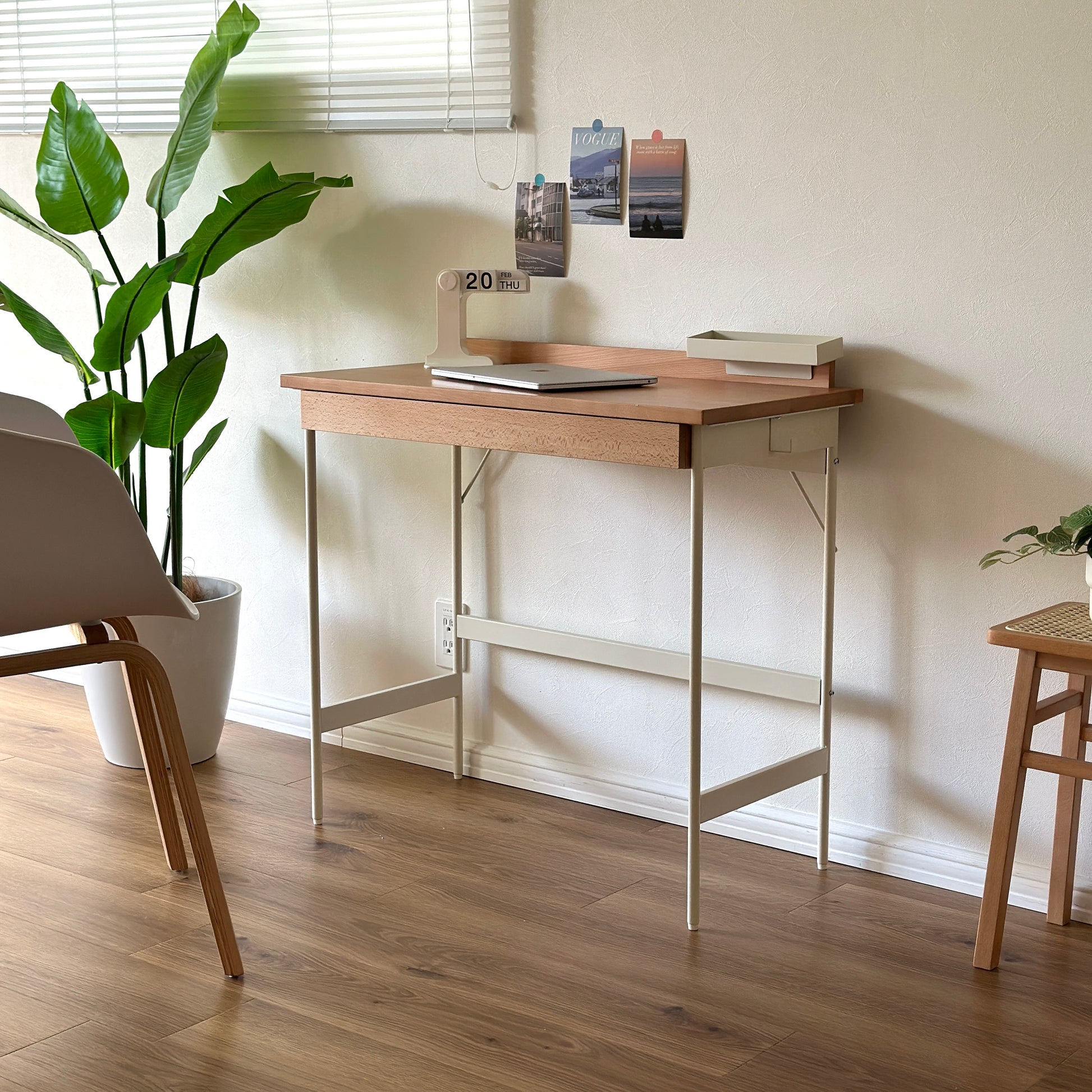 ウッドとスチール素材のデスクにパソコンやカレンダーを置いている様子