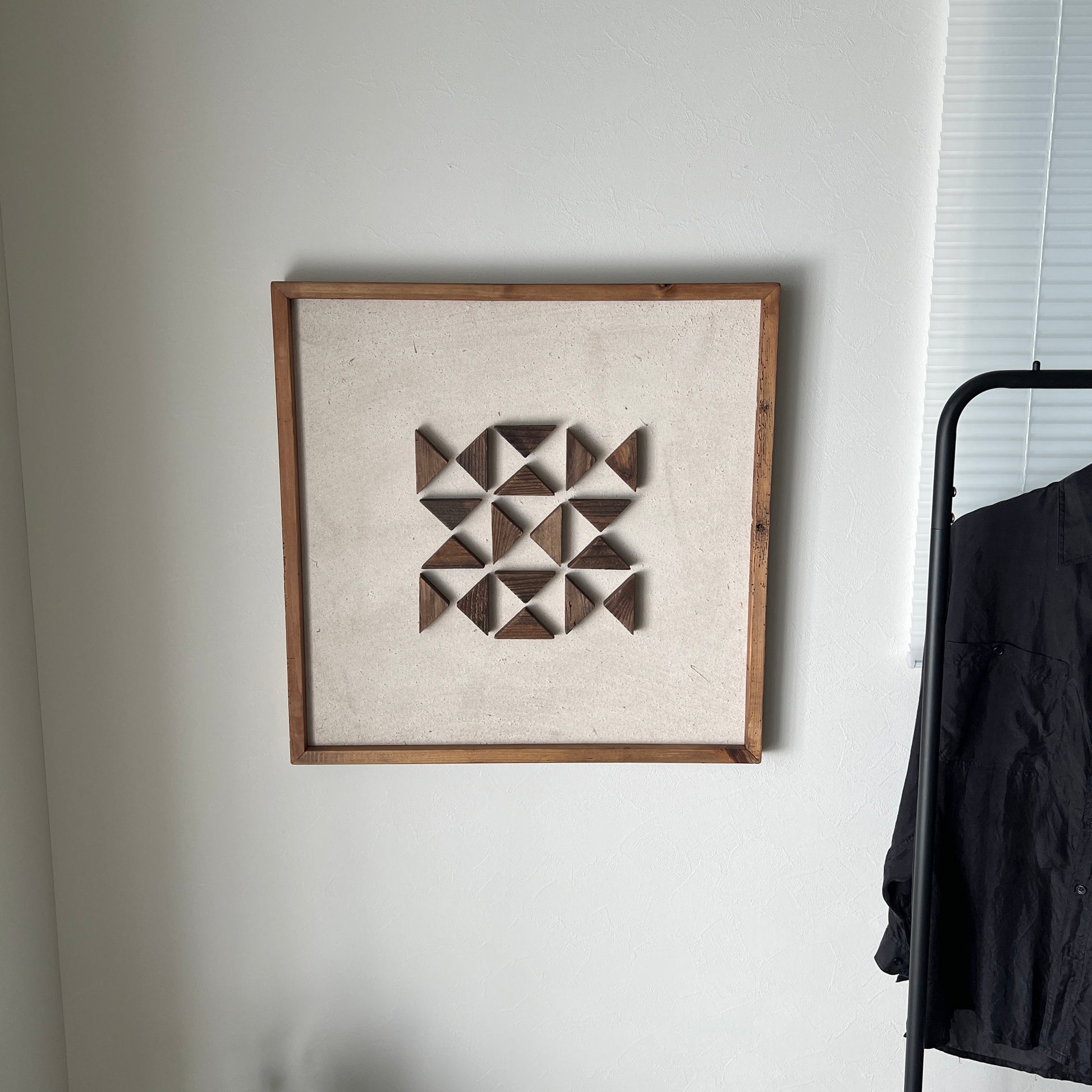 三角形の立体的なウッドパーツが幾何学的に貼り付けられたアート