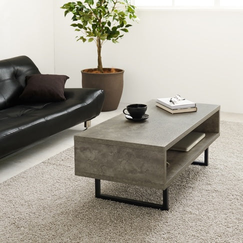 リビングに黒の革のソファとコンクリート風のスタイリッシュなローテーブルが置いてある部屋