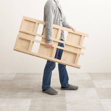 折畳みウッドラックを人が手で持ち運んでいる様子