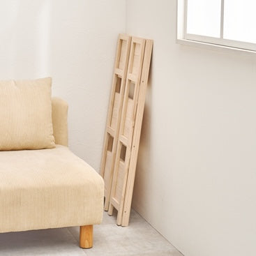 折畳みウッドラックが折り畳まれてソファ横に置いている様子