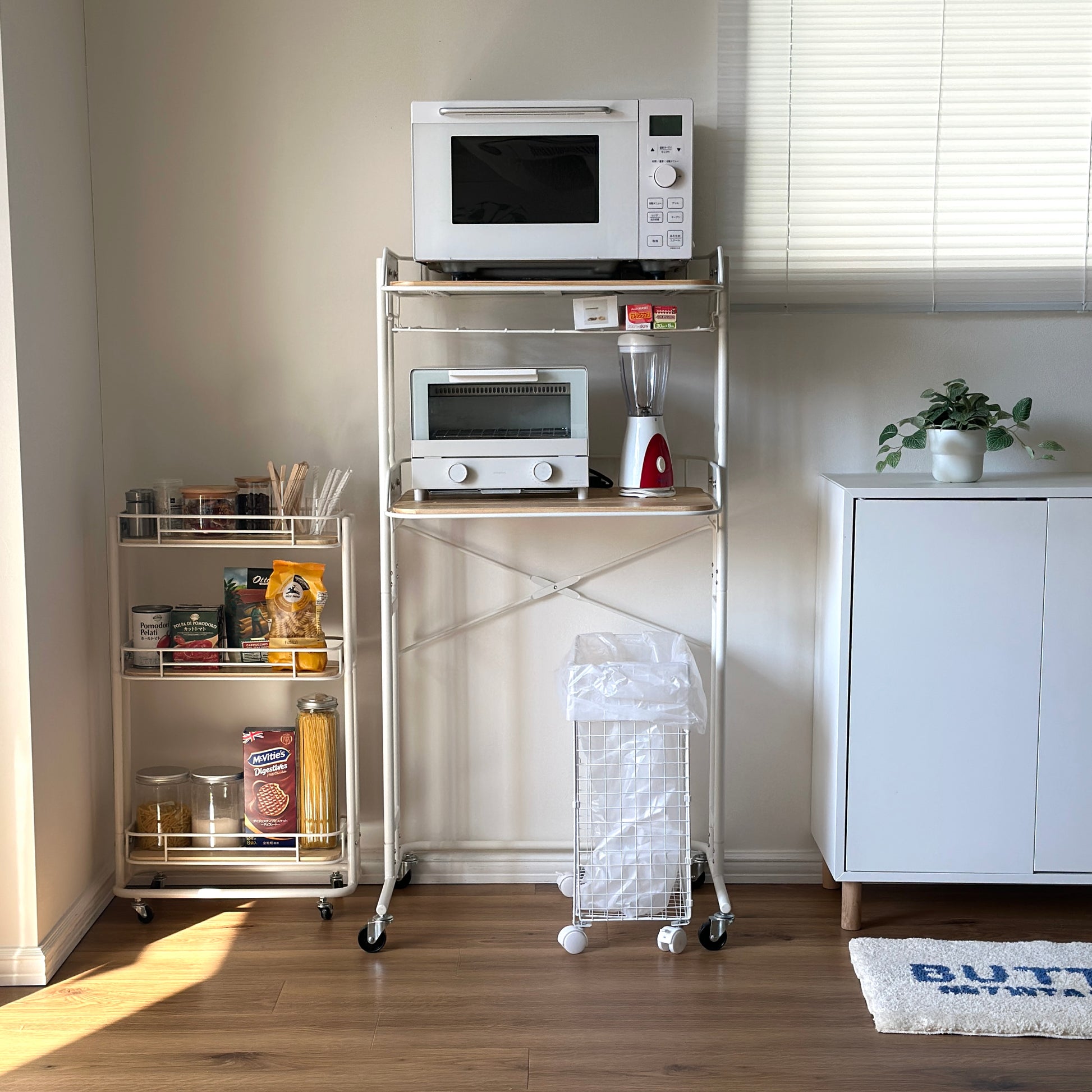 ホワイトとウッドのキッチンラックにキッチン用品が置かれている様子