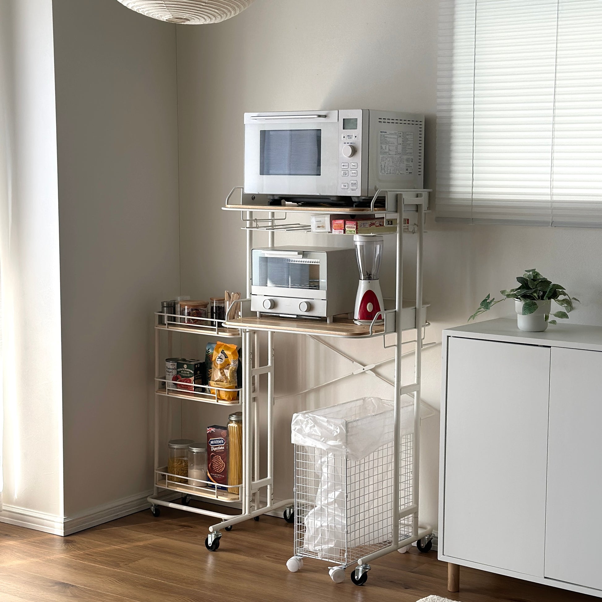 ホワイトとウッドのキッチンラックにキッチン用品が置かれている様子