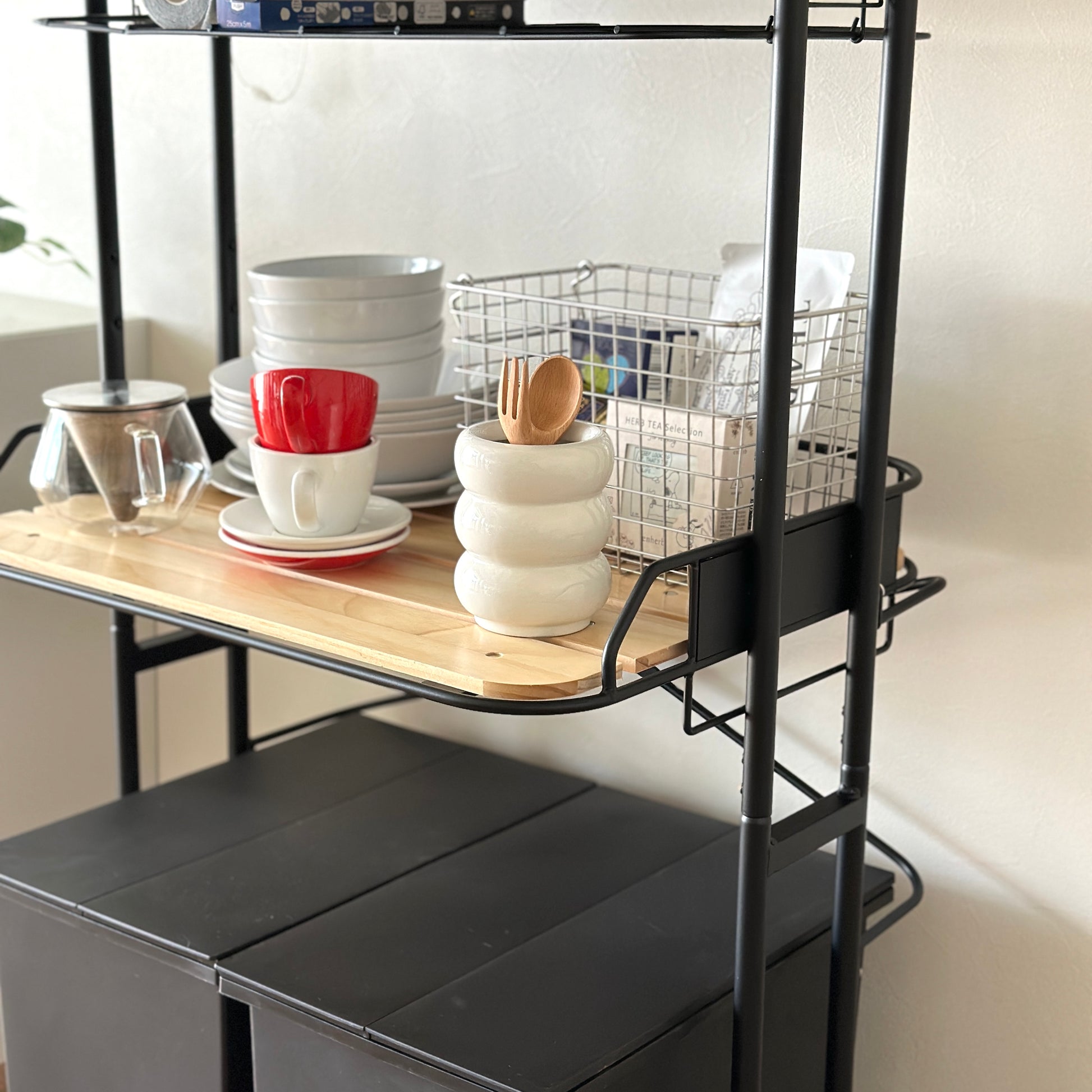 ブラックとウッドのキッチンラックにキッチン用品が置かれている様子