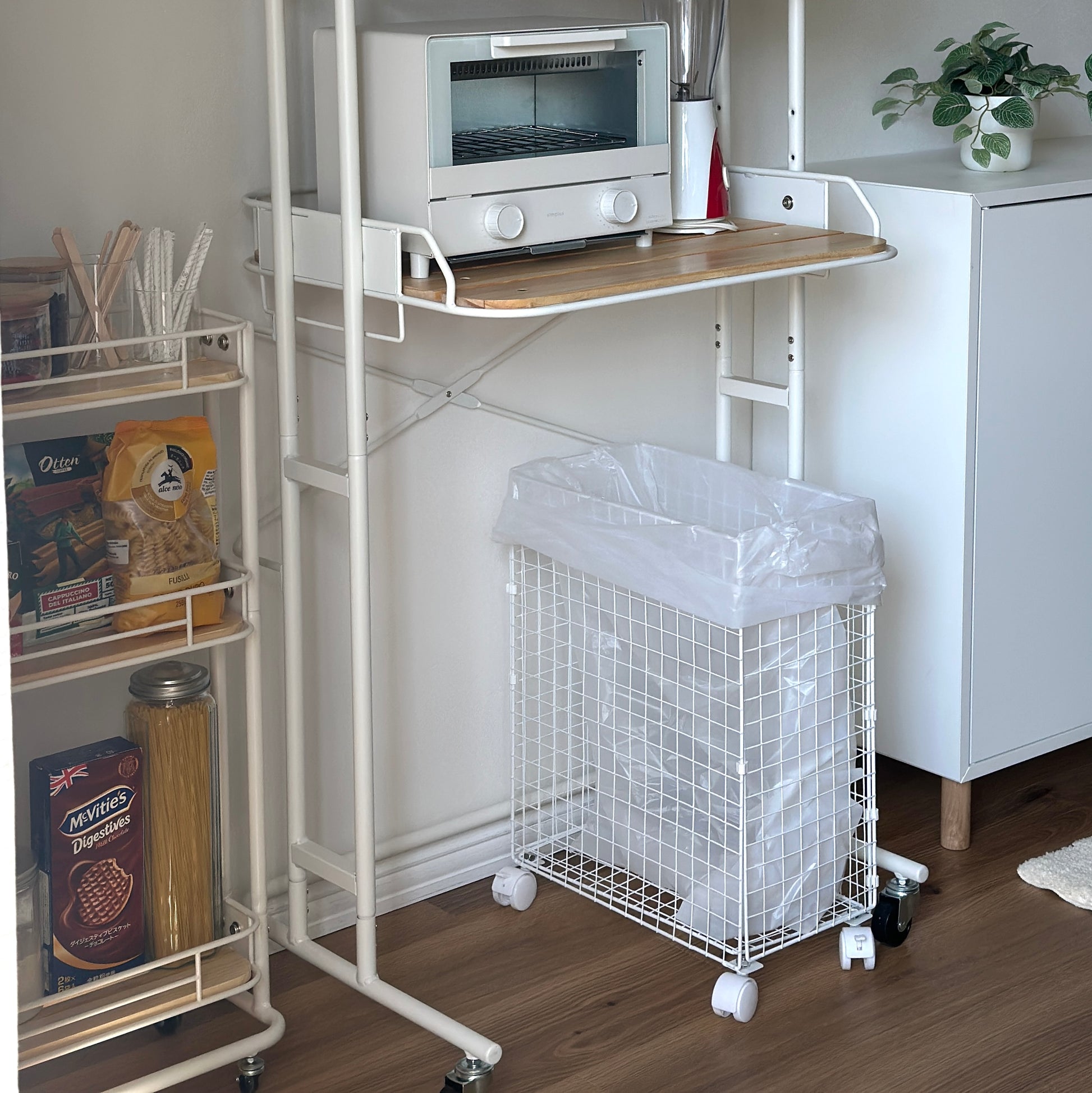 ホワイトとウッドのキッチンラックにキッチン用品が置かれている様子
