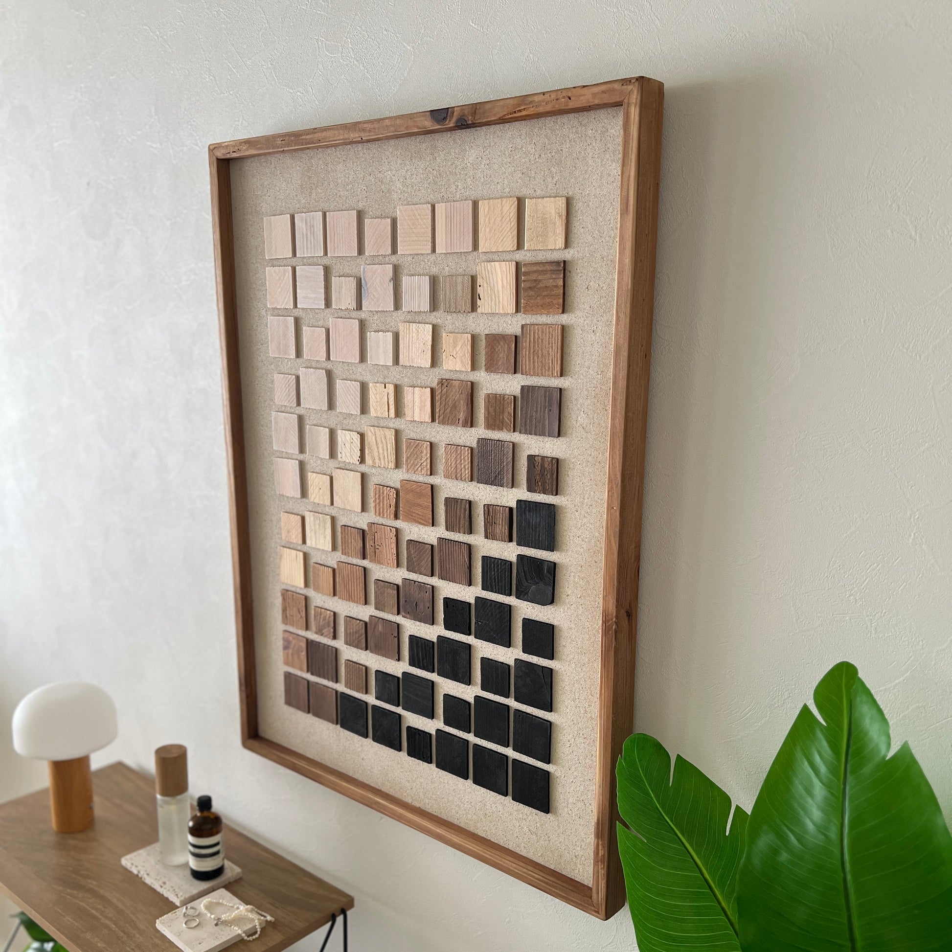 ウッドチップが立体的に貼り付けられたアートが壁にかかっている様子