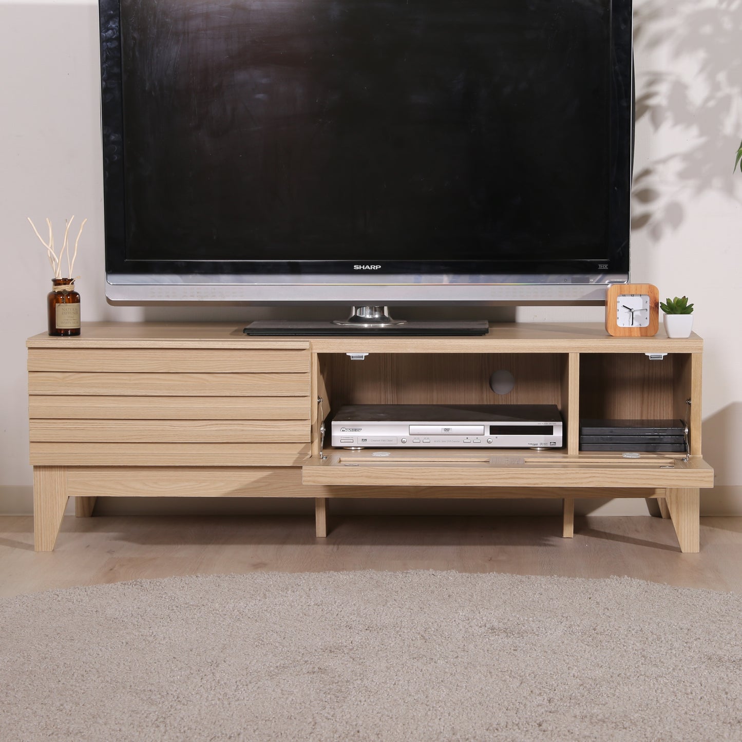 格子デザインのナチュラルウッドのテレビボードの前開き収納の中にDVDプレイヤーが入ってある