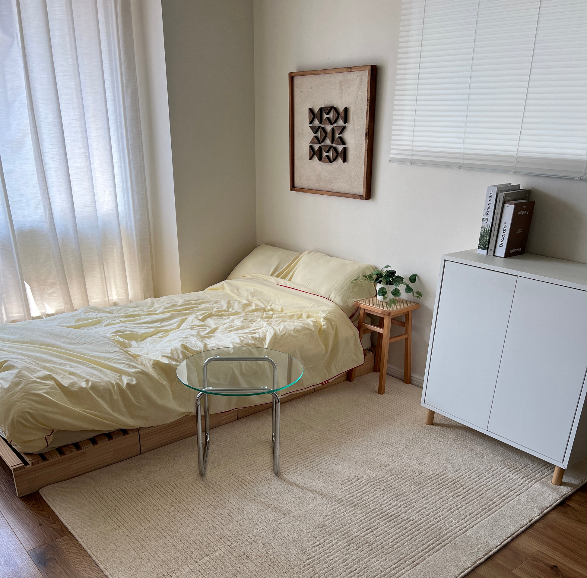 三角形の立体的なウッドパーツが幾何学的に貼り付けられたアートが部屋の壁にかけられている様子