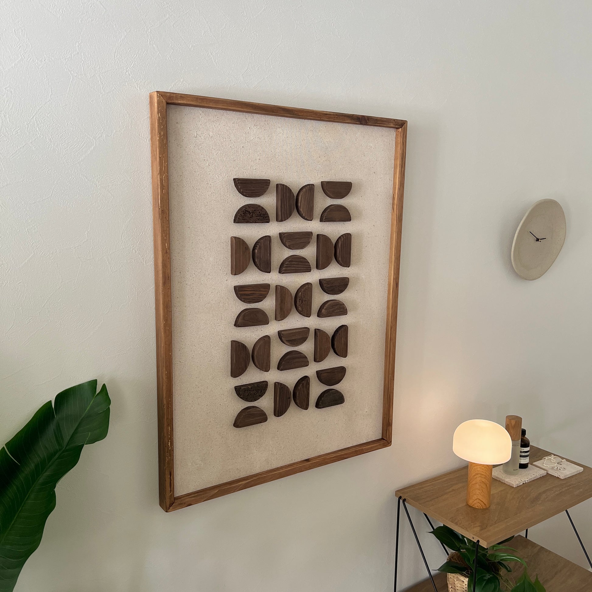 半円型の立体的なウッドパーツが幾何学的に貼り付けられたアート