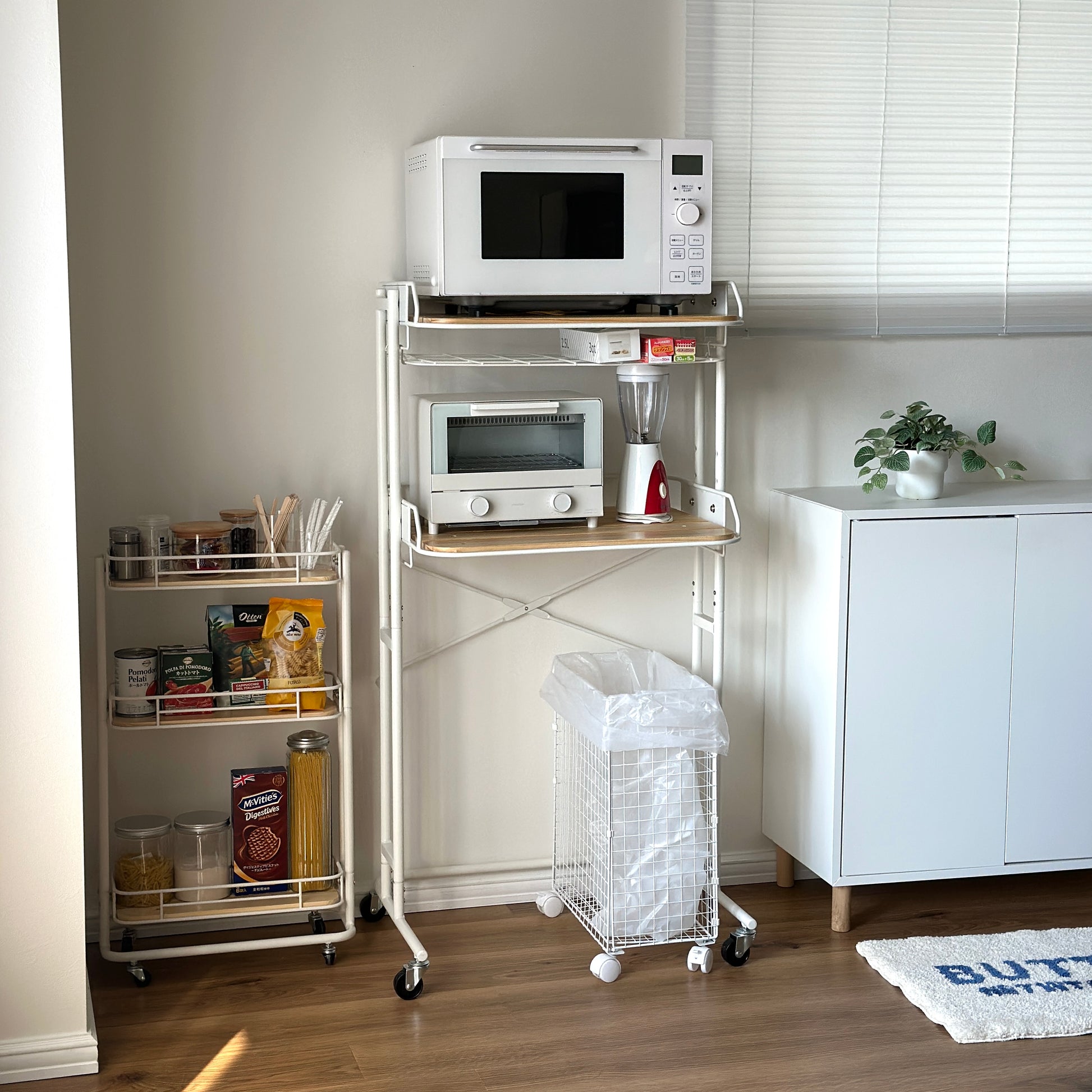 ホワイトとウッドのキッチンラックにキッチン用品が置かれている様子