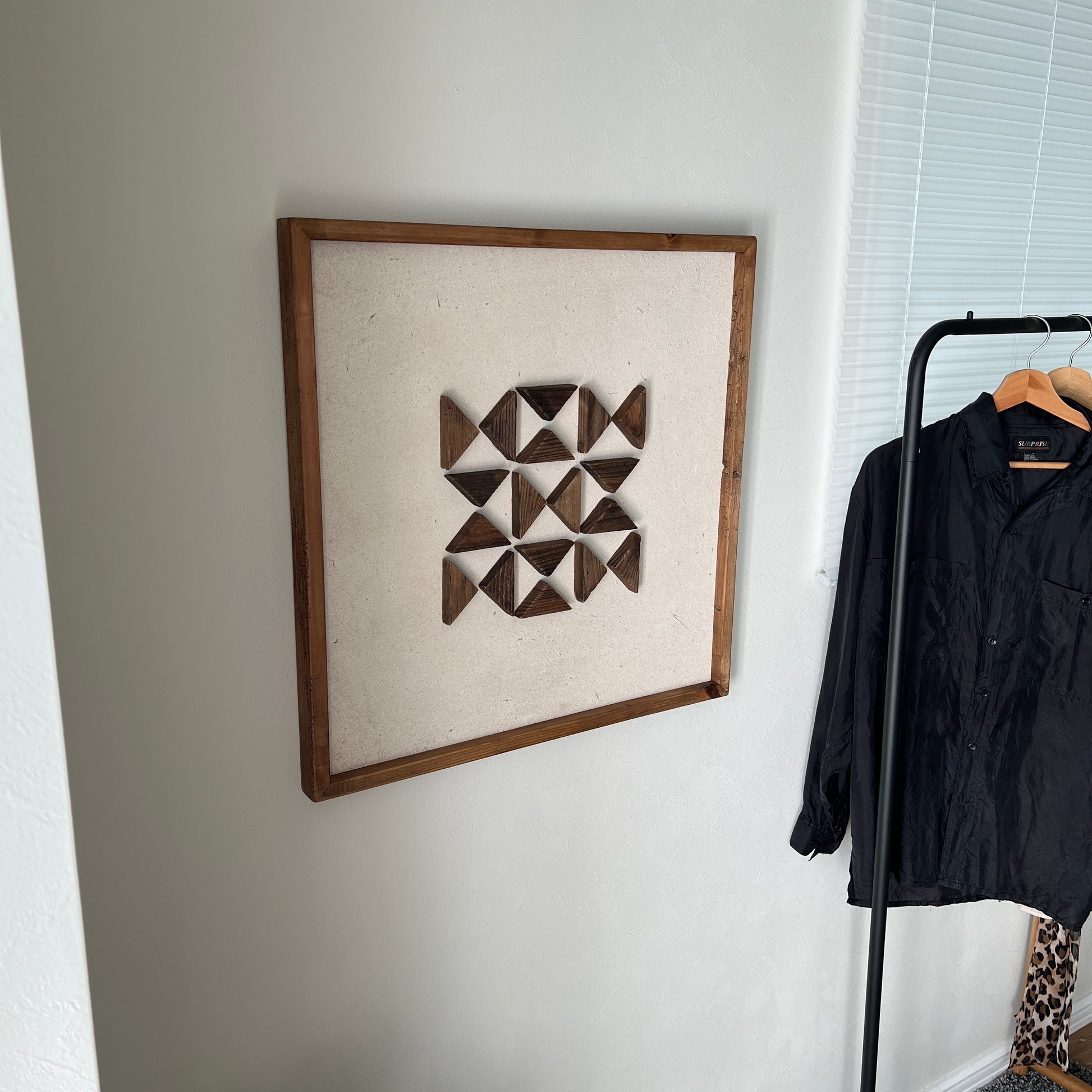 三角形の立体的なウッドパーツが幾何学的に貼り付けられたアート