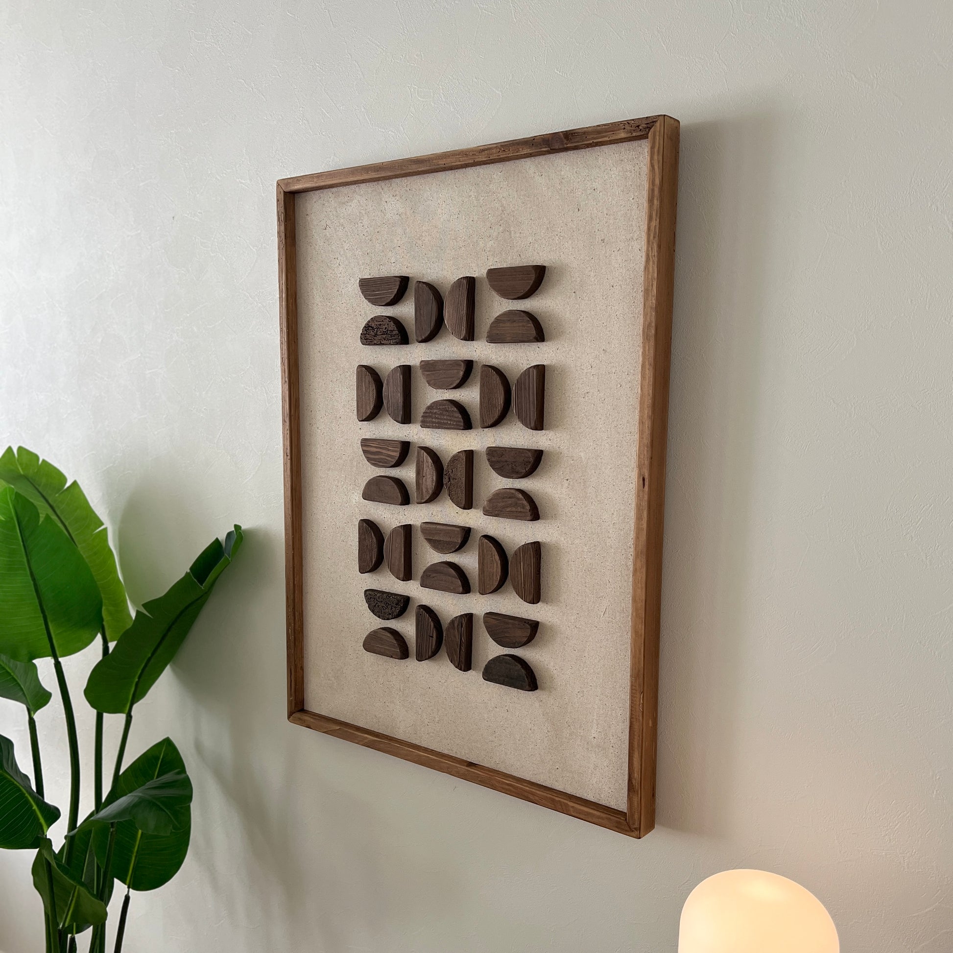 半円型の立体的なウッドパーツが幾何学的に貼り付けられたアート