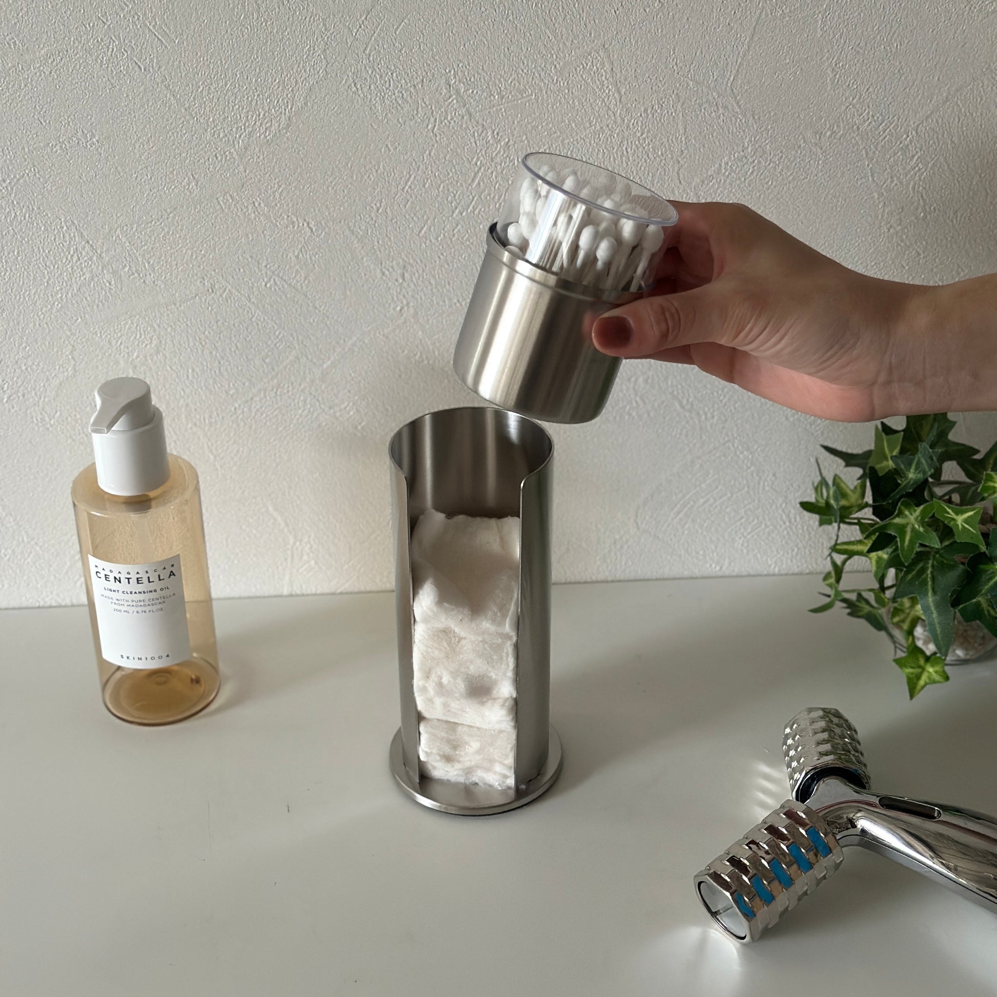 ステンレス素材のコットンと綿棒の縦型収納ケースの綿棒の収納部分を取っている様子