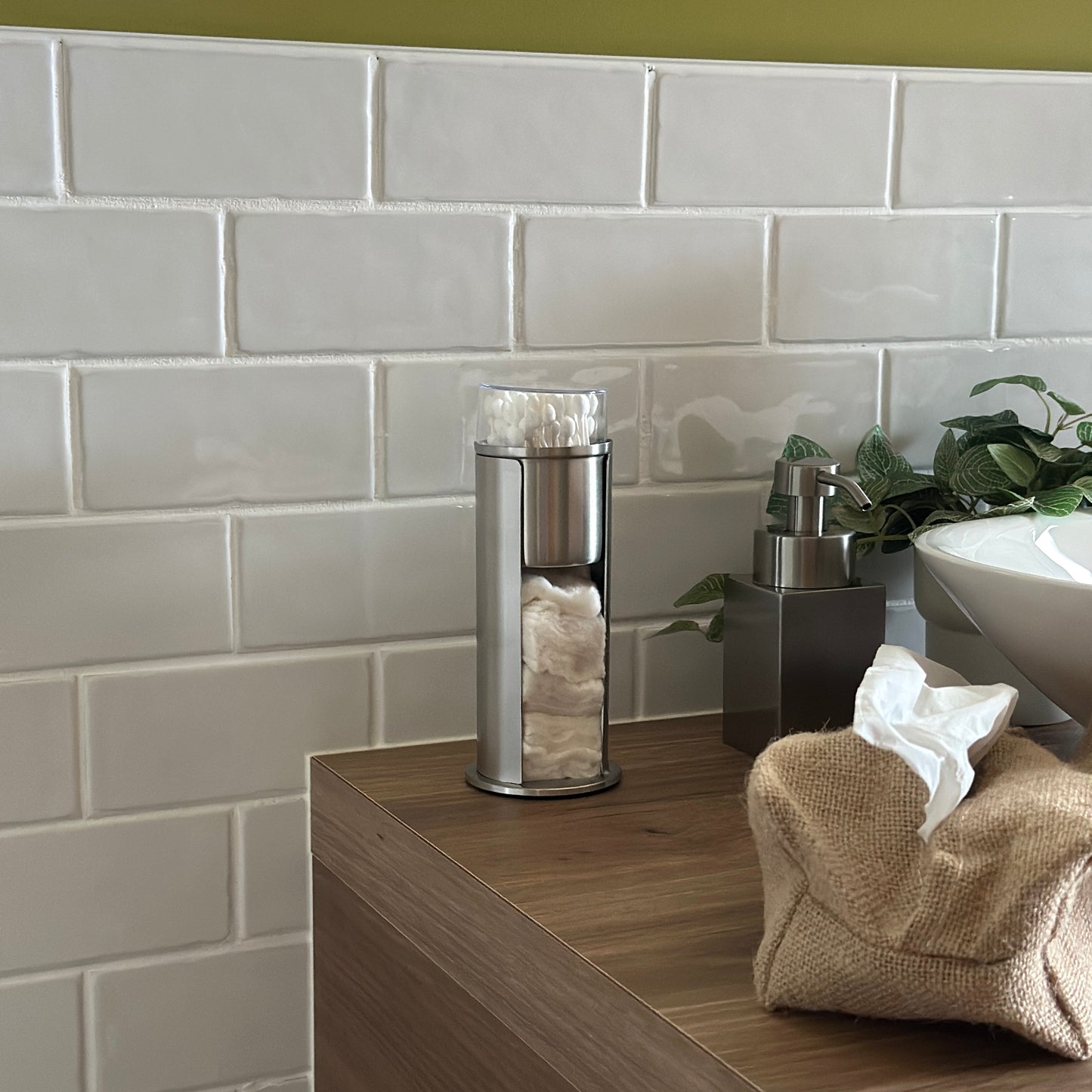 ステンレス素材のコットンと綿棒の縦型収納ケースを洗面台に置いている様子