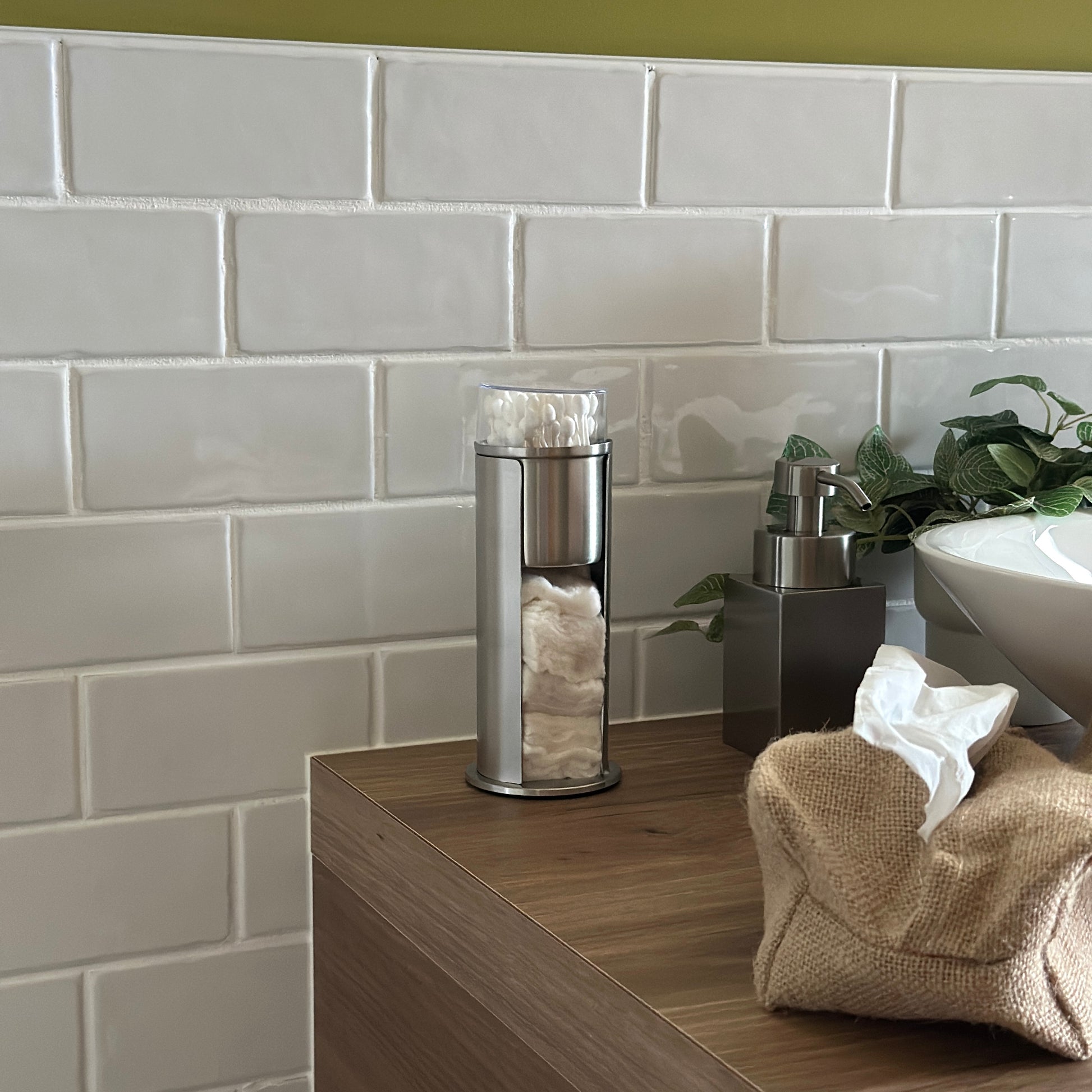 ステンレス素材のコットンと綿棒の縦型収納ケースを洗面台に置いている様子