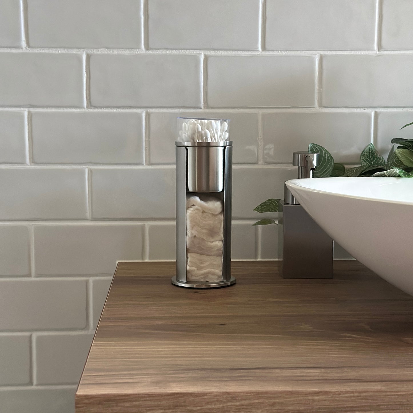 ステンレス素材のコットンと綿棒の縦型収納ケースを洗面台に置いている様子