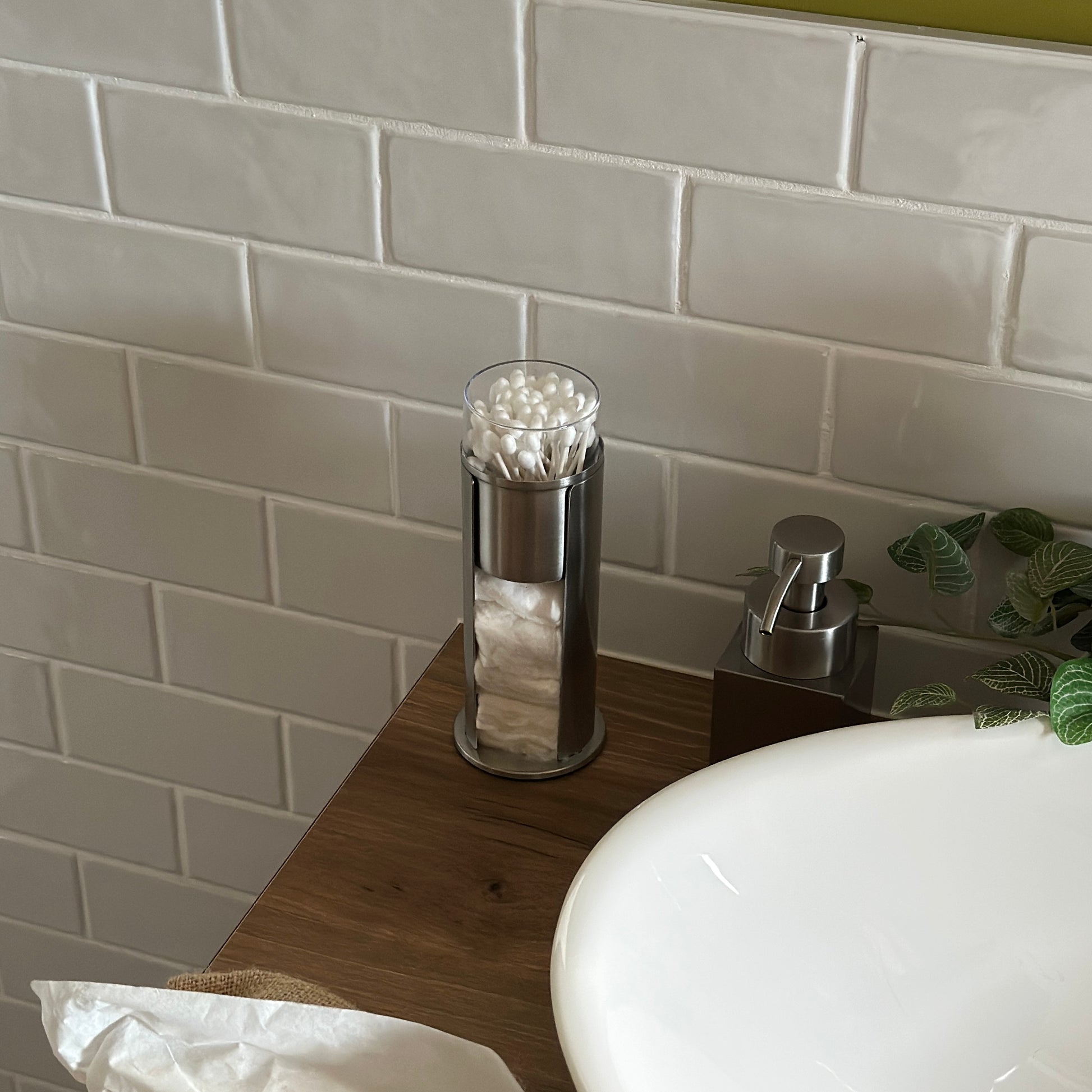 ステンレス素材のコットンと綿棒の縦型収納ケースを洗面台に置いている様子