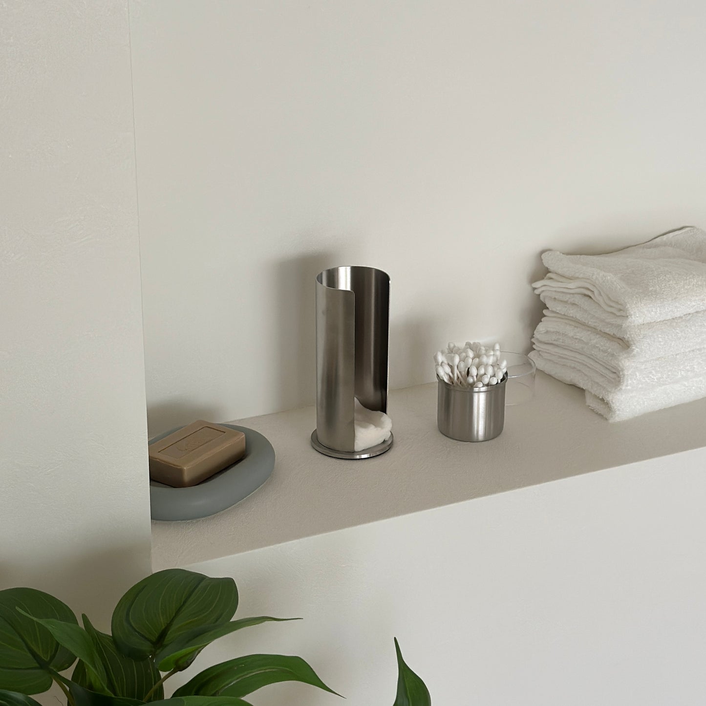 ステンレス素材のコットンと綿棒の縦型収納ケースの綿棒の収納部分を取っている様子