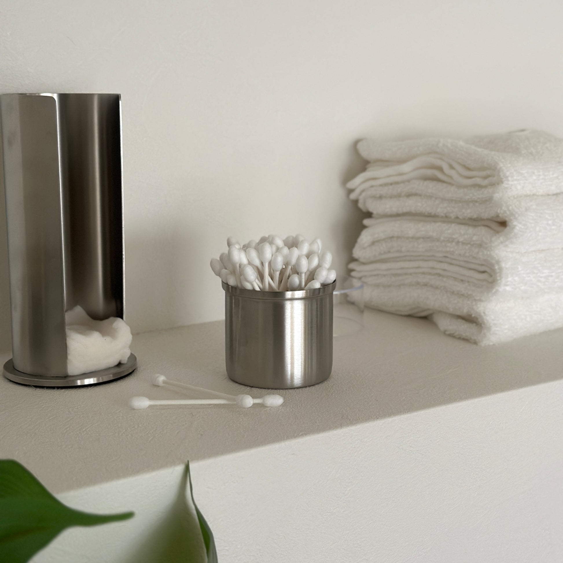 ステンレス素材のコットンと綿棒の縦型収納ケースの綿棒の収納部分を取っている様子