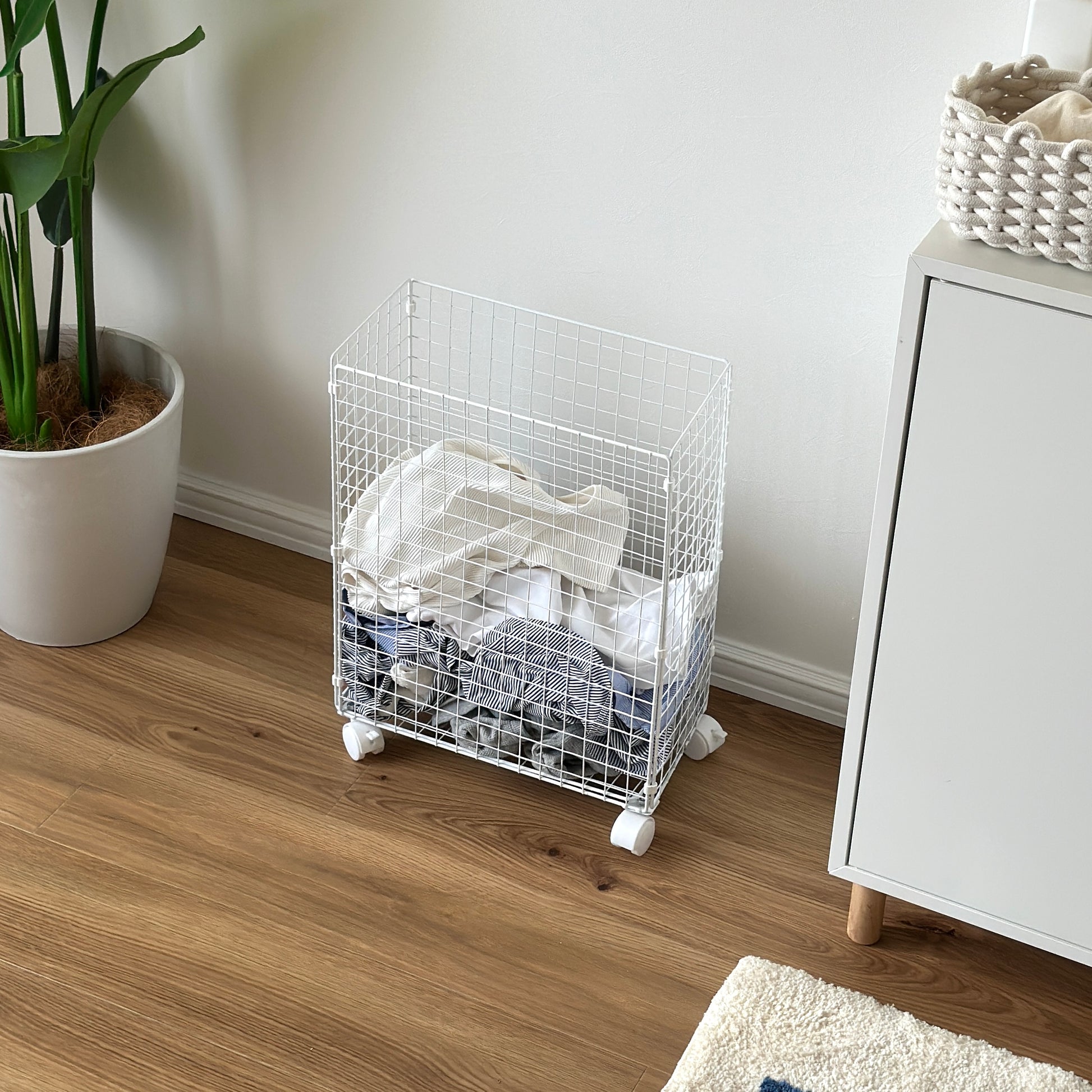 ホワイトのメッシュのランドリーワゴンの中に洋服が入っている様子