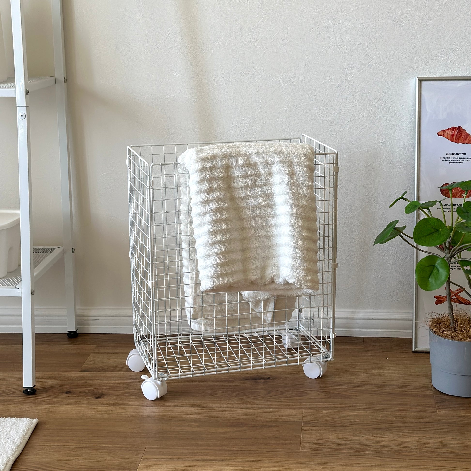 ホワイトのメッシュのランドリーワゴンにタオルがかかっている様子