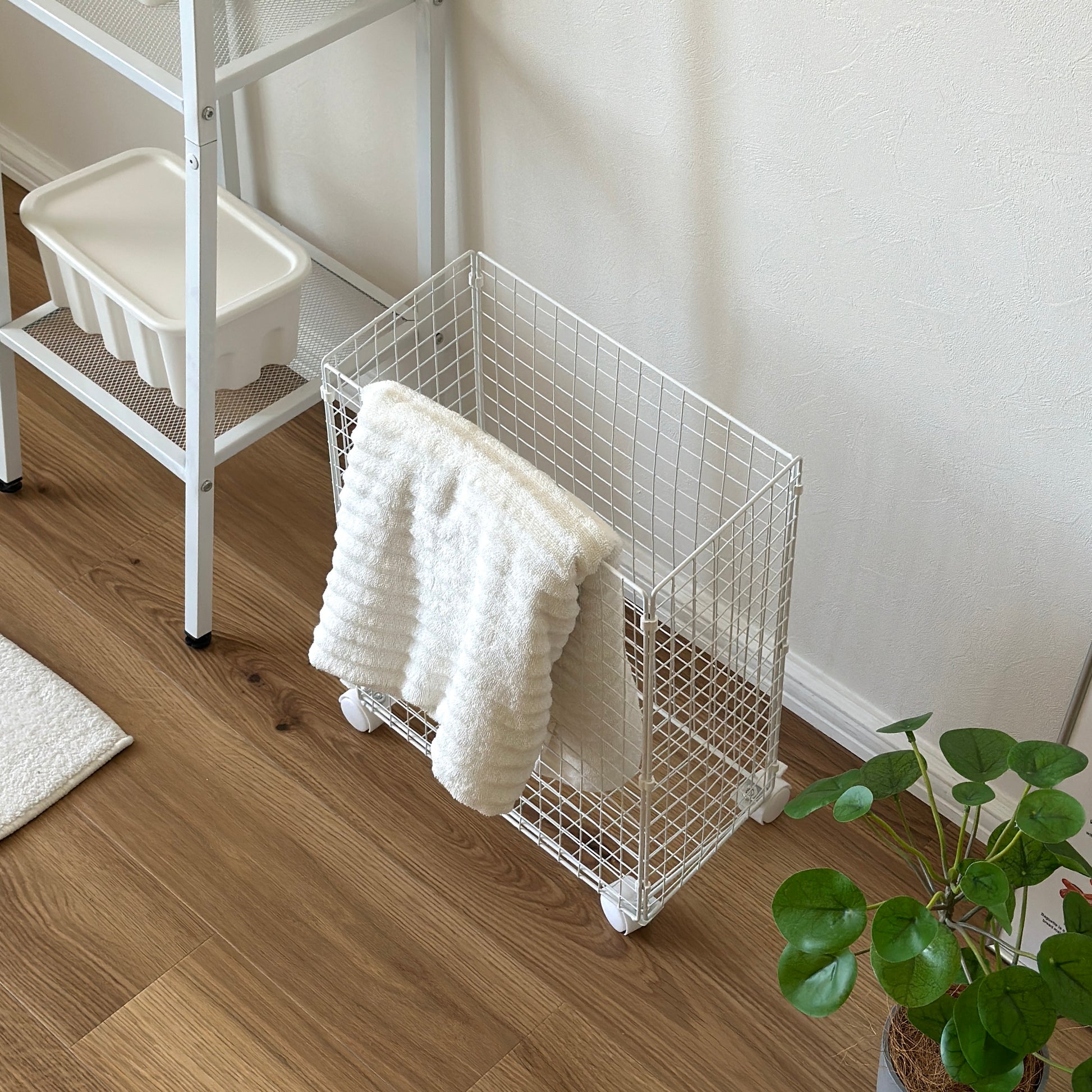 ホワイトのメッシュのランドリーワゴンにタオルがかかっている様子