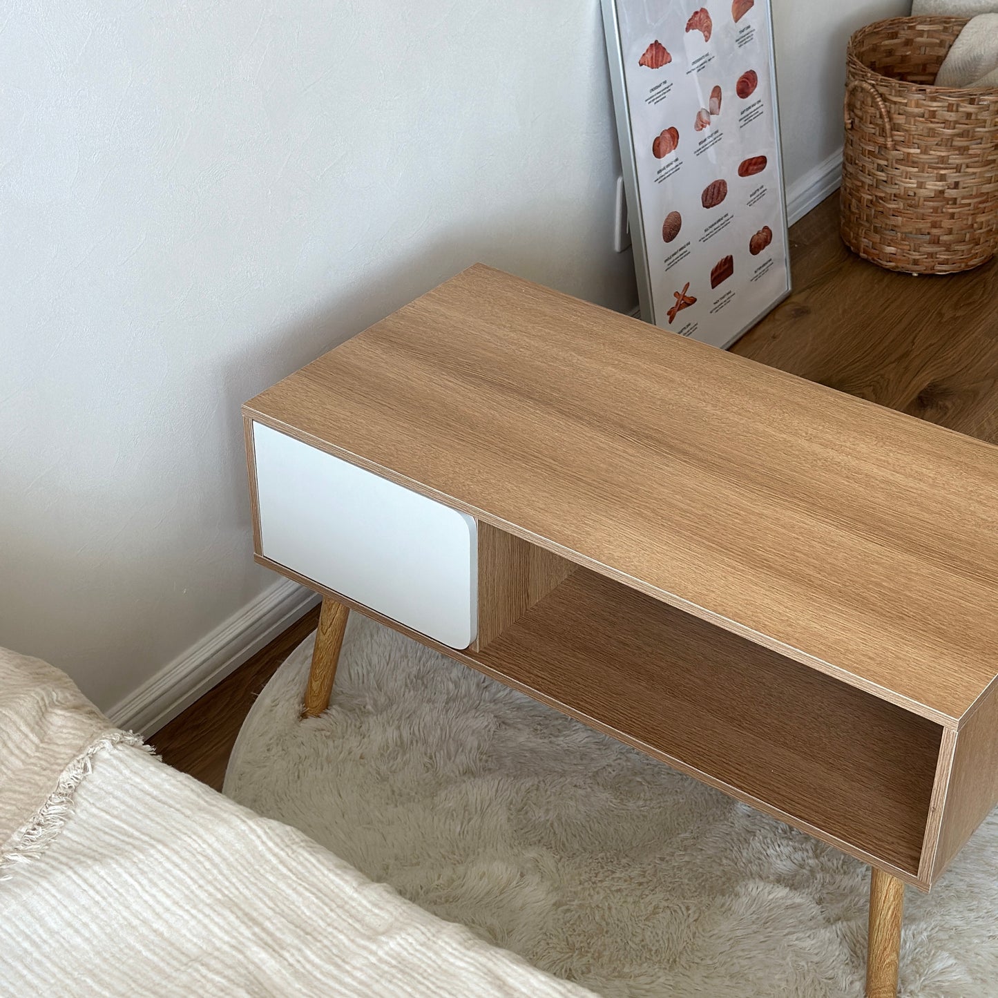 ナチュラルウッドカラーの扉付きローテーブルがベッドの前に置かれている様子