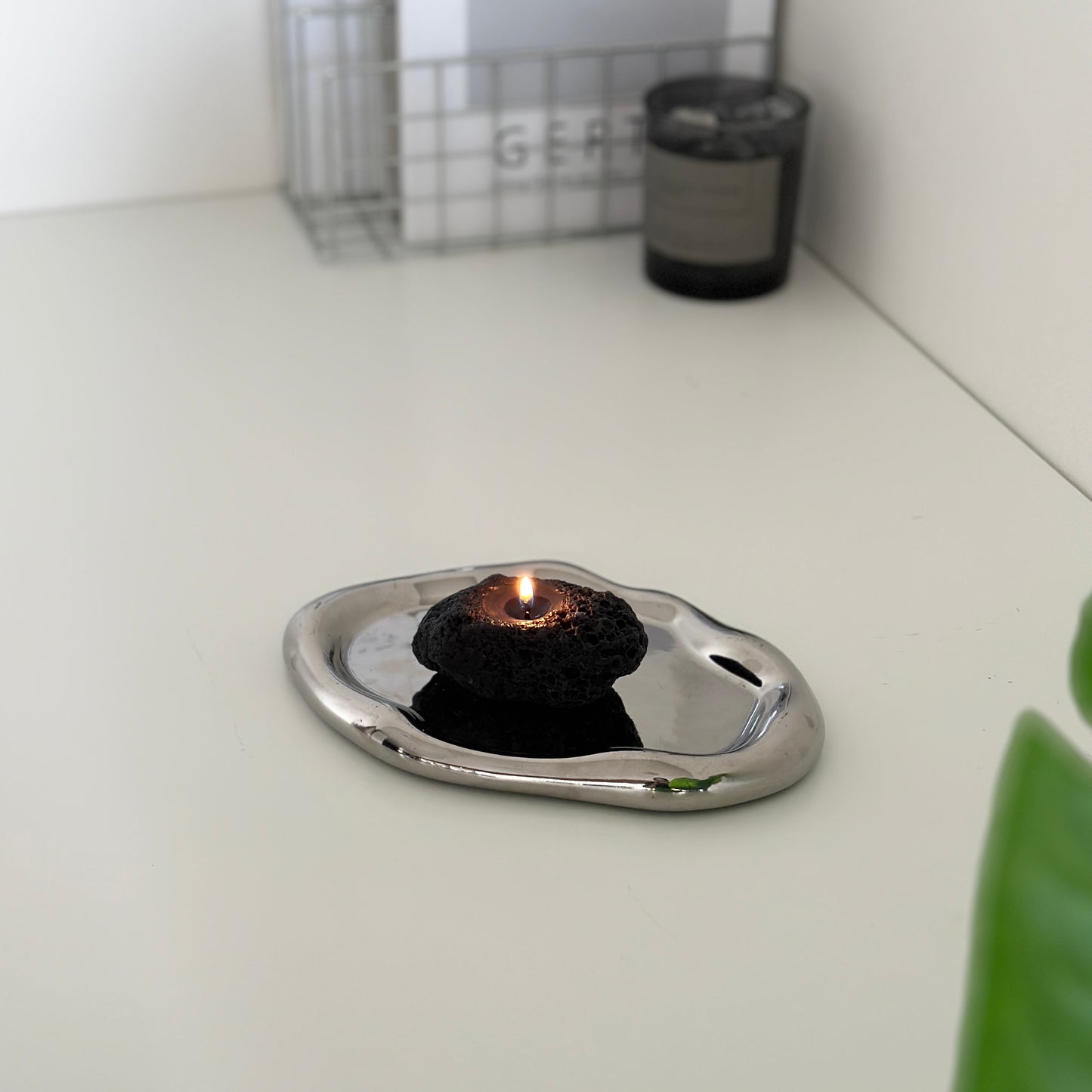 シルバーのプレートに乗せられた黒い石のキャンドル