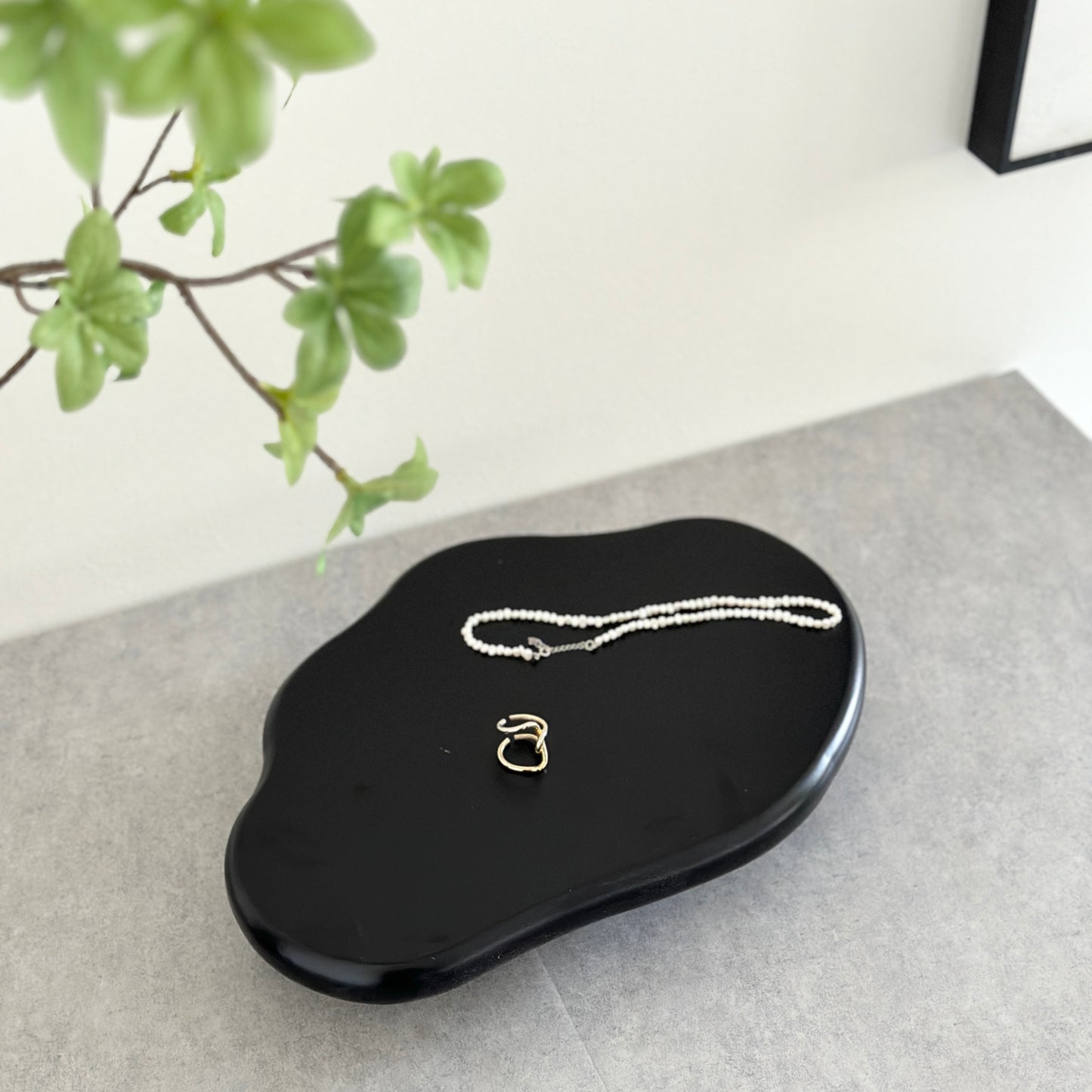 木製の黒の大きなトレイの上にアクセサリーが置かれている