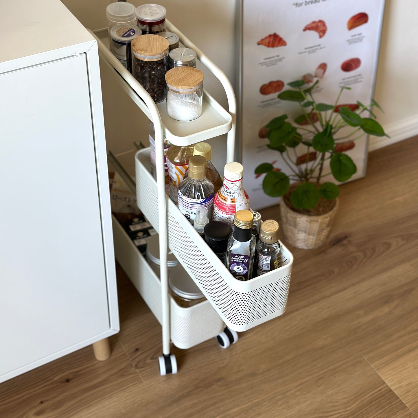 ホワイトの3段のスライド式の隙間収納に調味料がたくさん収納されている様子