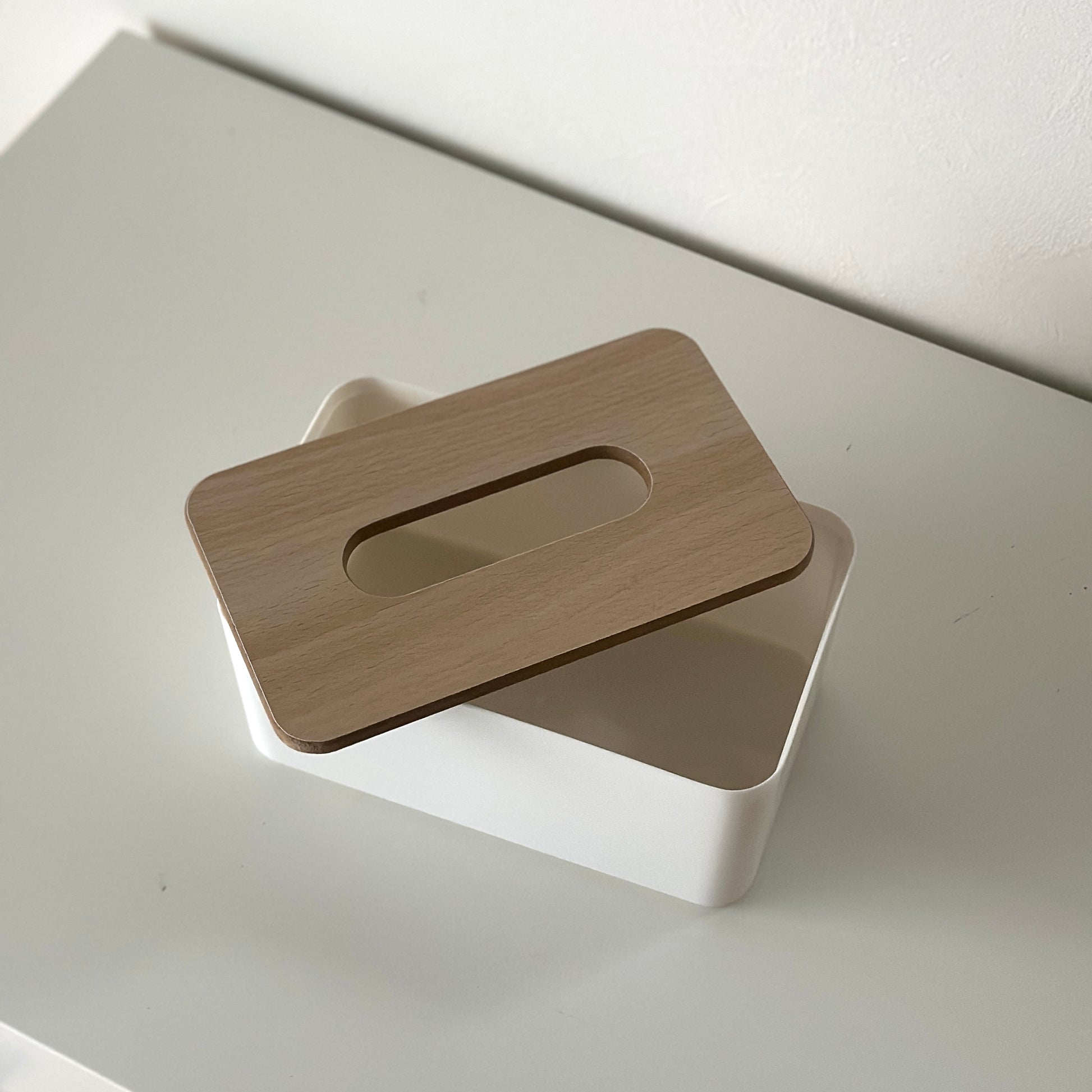ウッド蓋がついたシンプルなデザインのティッシュケースが棚の上に置かれている様子