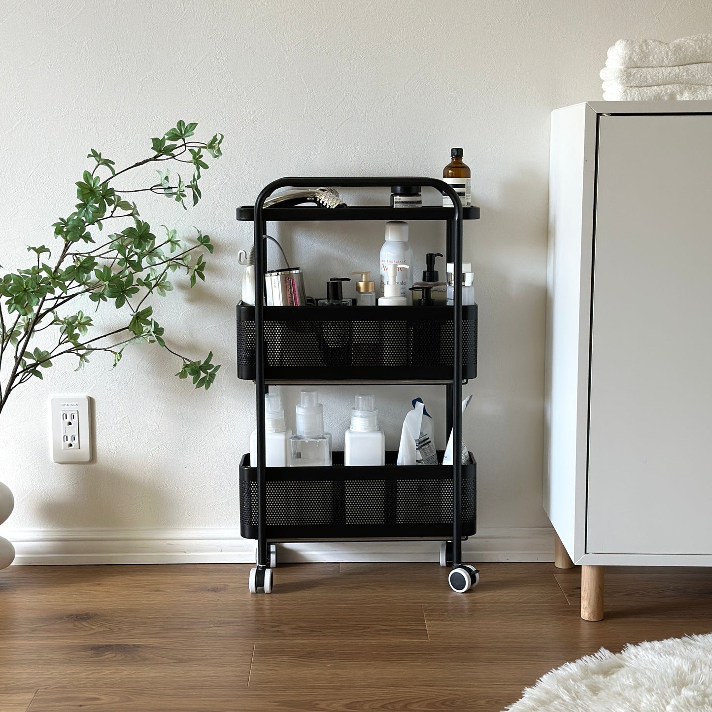 ブラックの3段のスライド式の隙間収納に洗面用品がたくさん収納されている様子