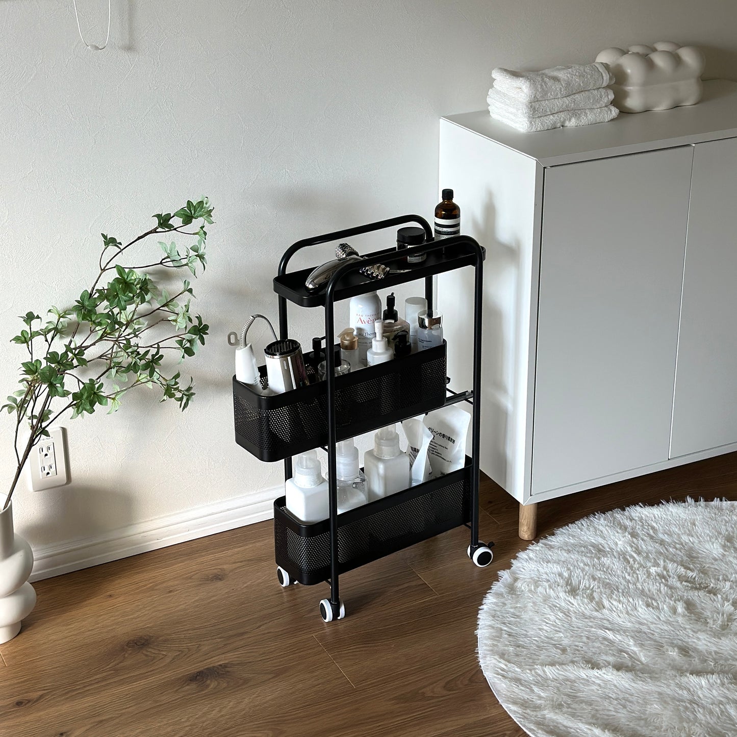 ブラックの3段のスライド式の隙間収納に洗面用品がたくさん収納されている様子