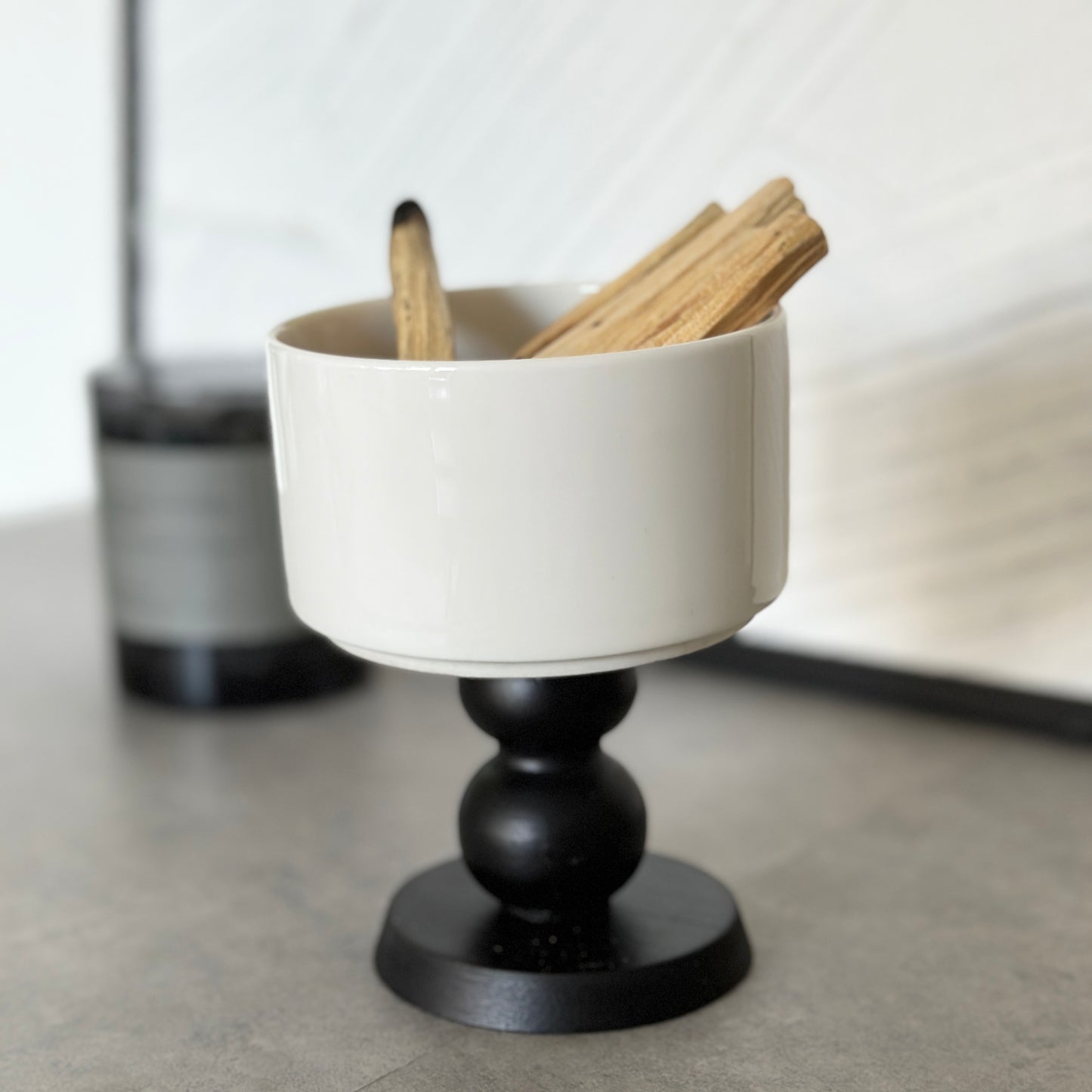 陶器の器に黒いウッド脚が付いたボウルが置かれてある。