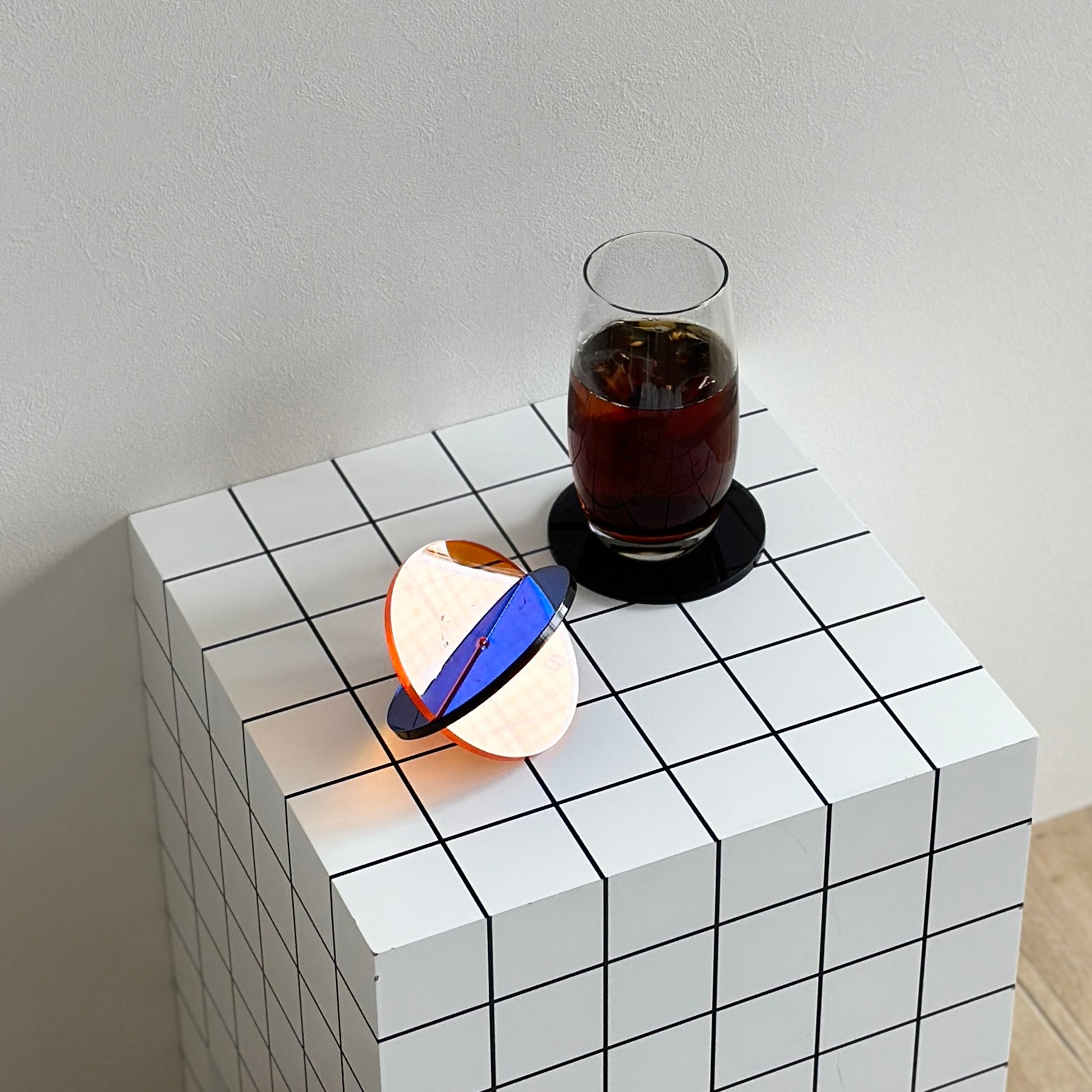 アクリルのコースターにコーヒーが入ったカップを置いている様子