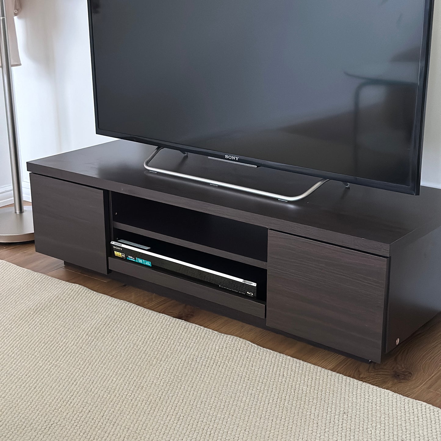 ダークブラウンのテレビボードの収納スペースにDVDプレイヤーが置かれている