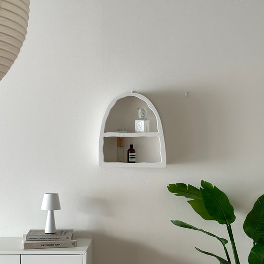 収納ポケットが2つ付いたドーム形のディスプレイラックに香水やキャンドルが並べられている