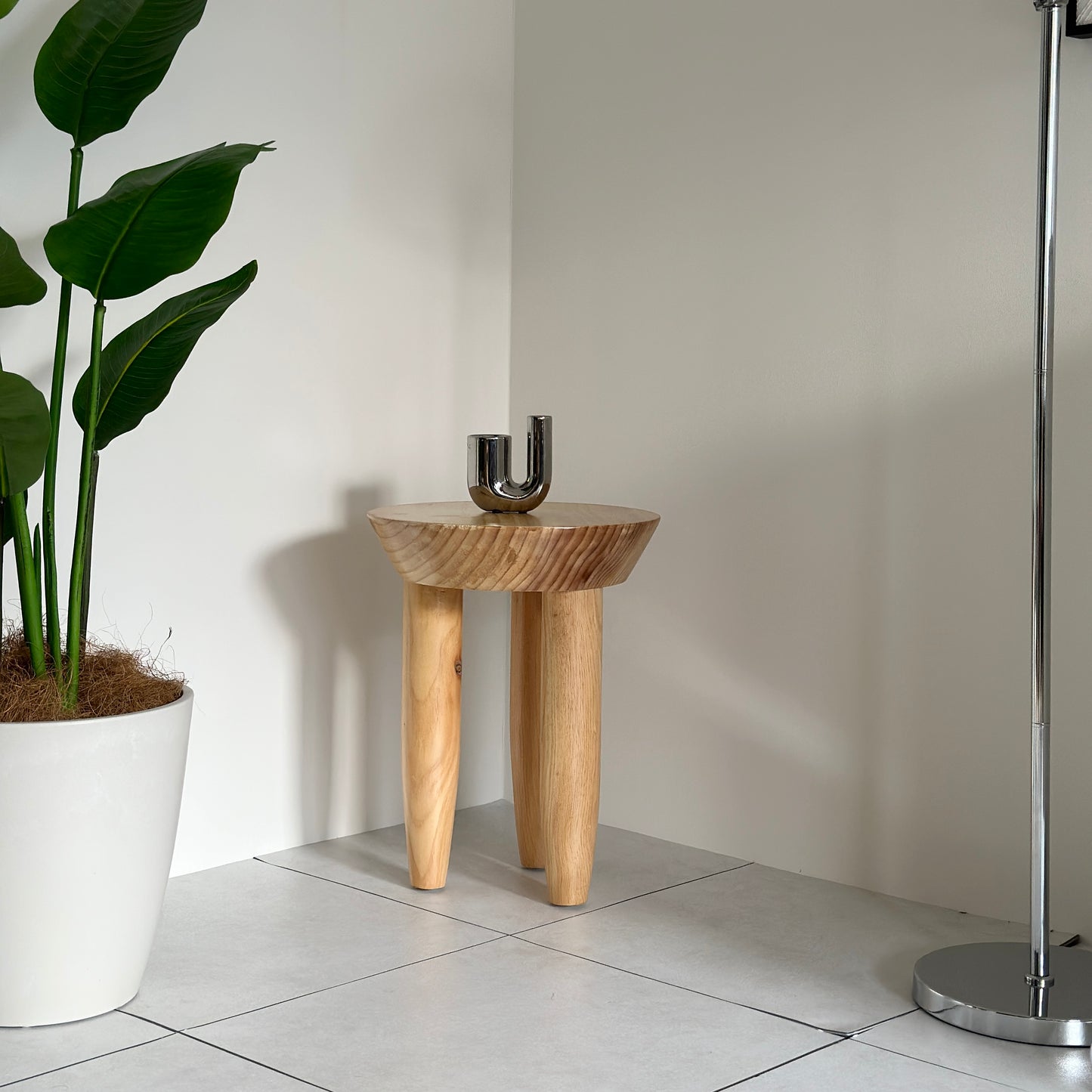 キャンドルホルダーが乗っているナチュラルウッドカラーの木製スツール