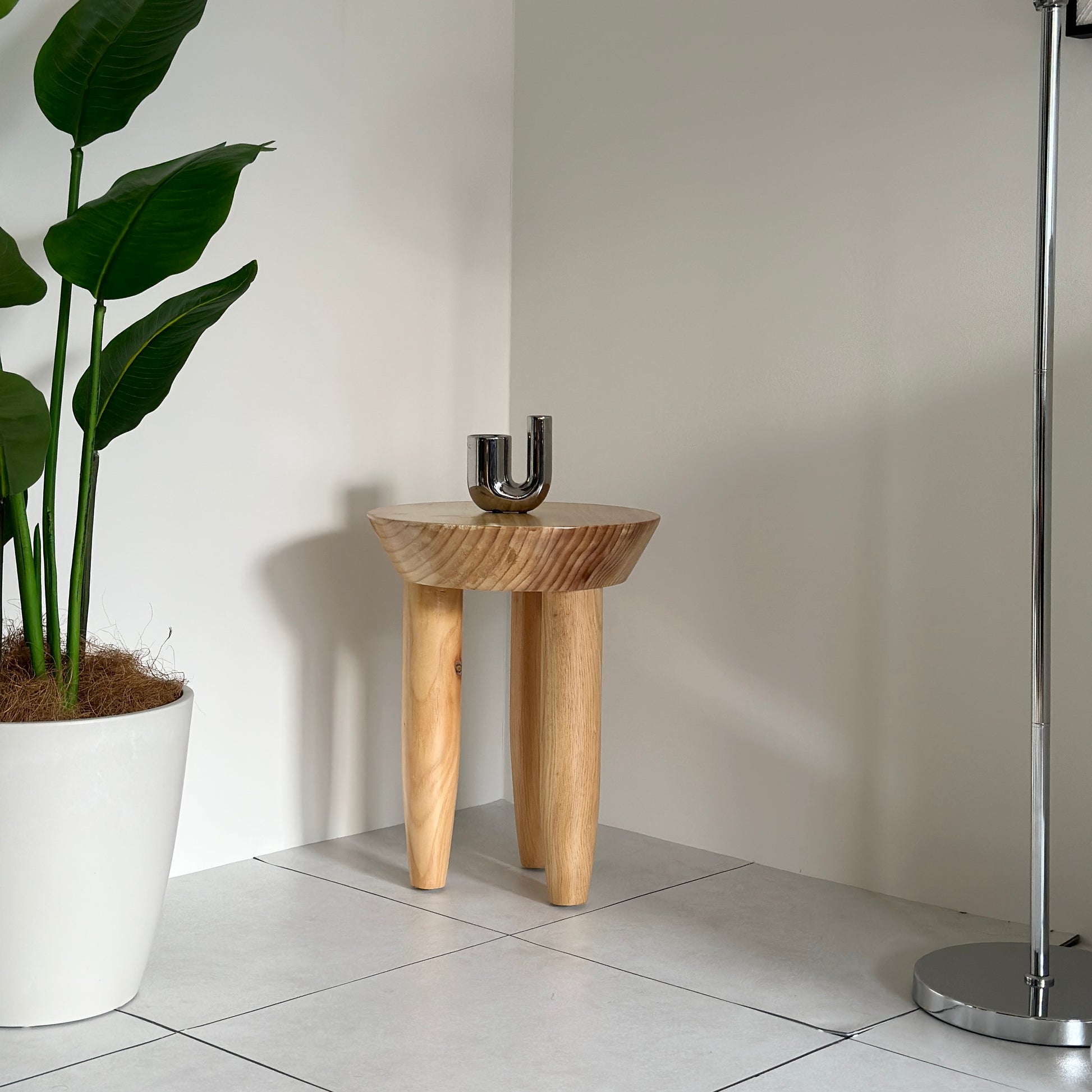 キャンドルホルダーが乗っているナチュラルウッドカラーの木製スツール