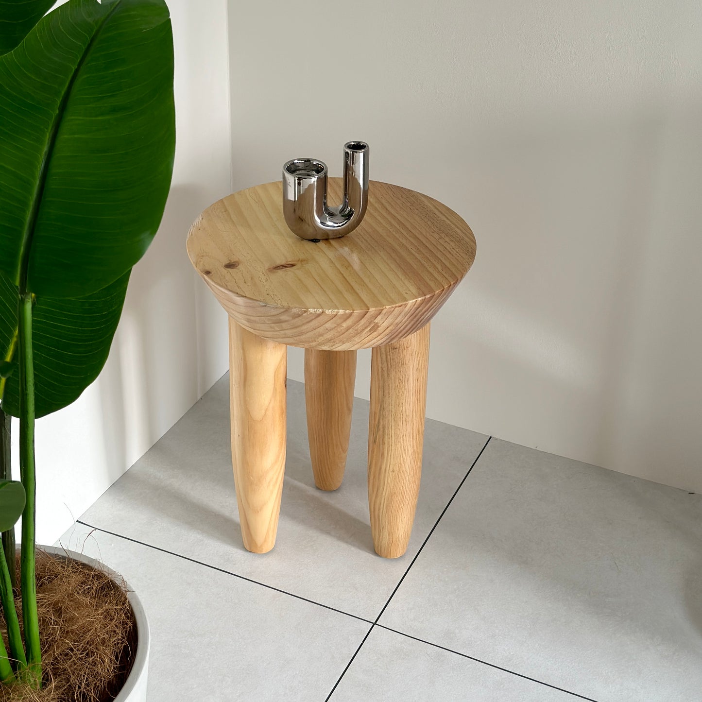 キャンドルホルダーが乗っているナチュラルウッドカラーの木製スツール