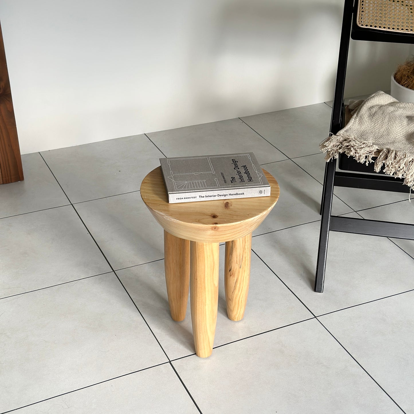 本が乗っているナチュラルウッドカラーの木製スツール