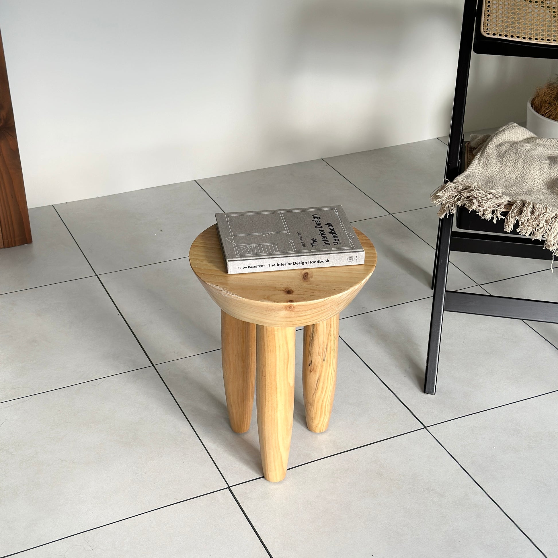 本が乗っているナチュラルウッドカラーの木製スツール