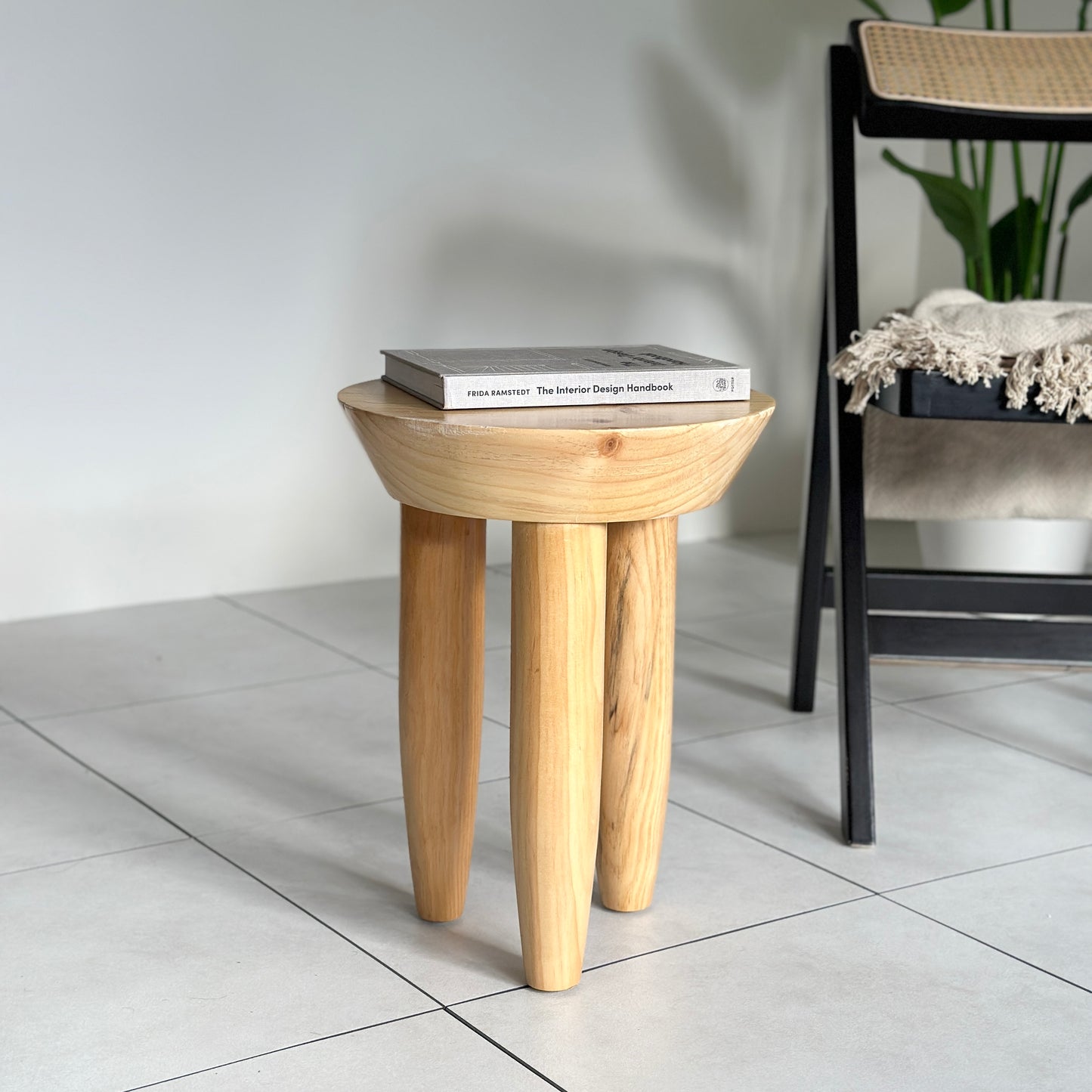 本が乗っているナチュラルウッドカラーの木製スツール