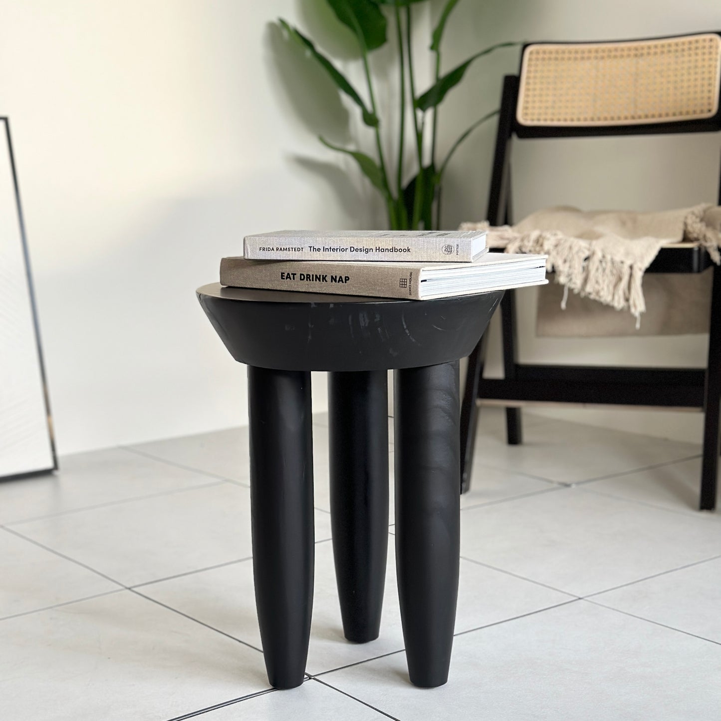 本が2冊乗っているブラックの木製スツール